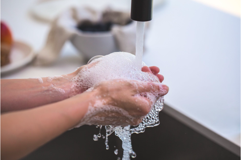 Soapy hands under running water
