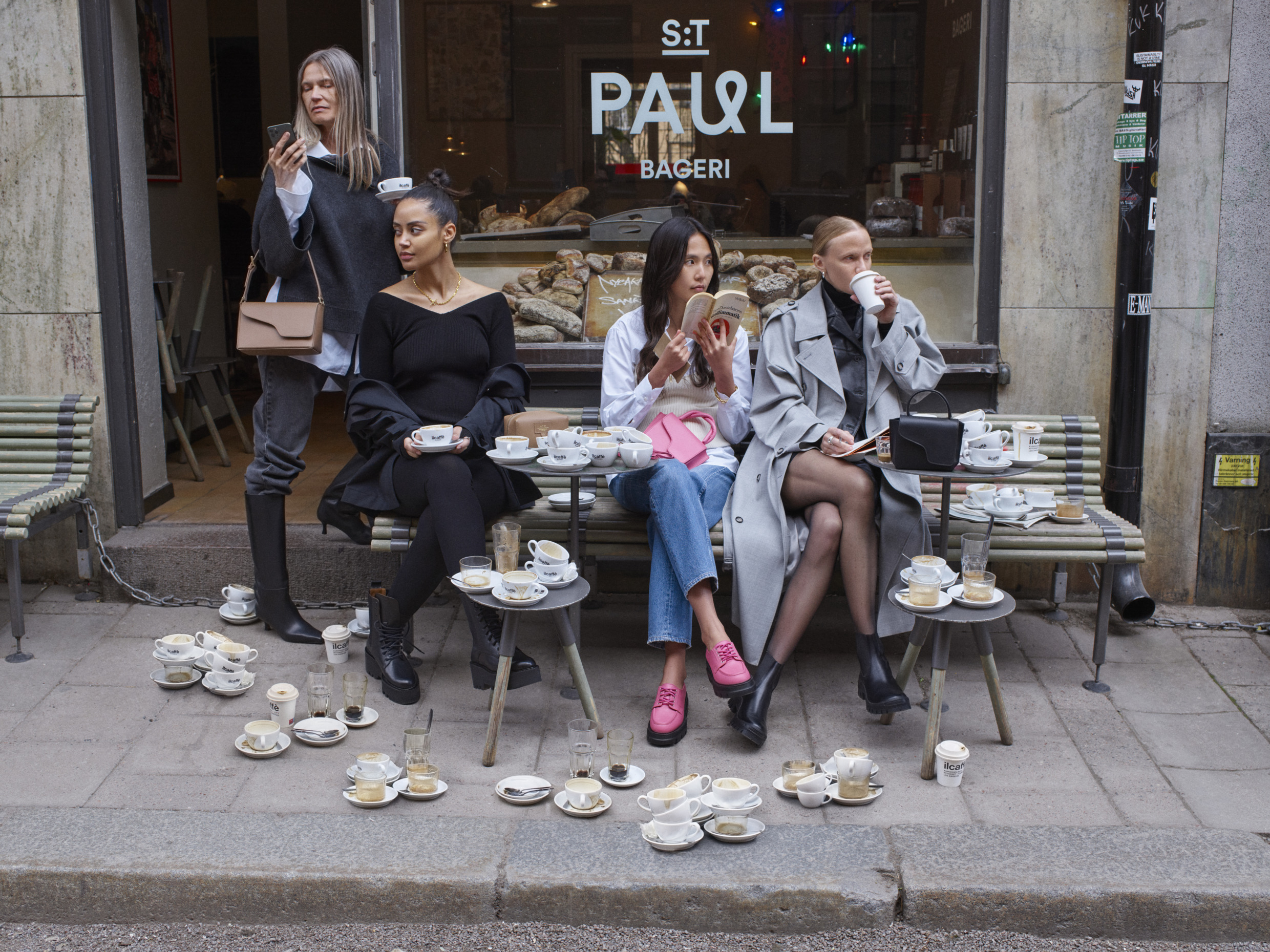 Modellen zitten buiten een café in Stockholm.