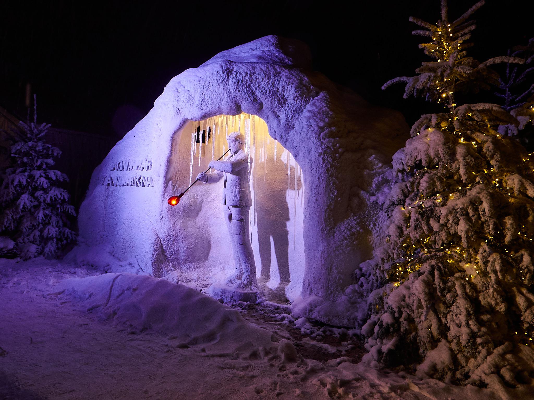Een sneeuwsculptuur van een glasblazende man op de kerstmarkt van Kosta.