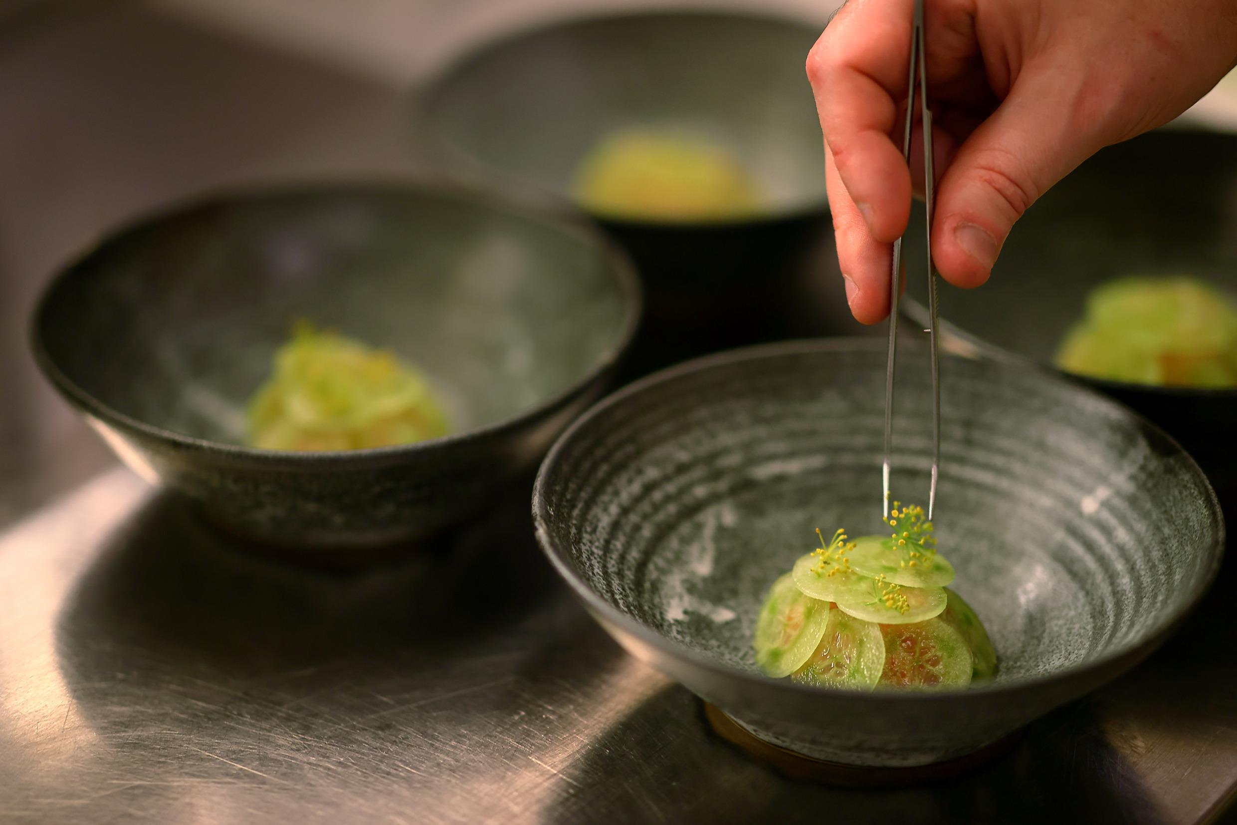 A close up of food being decorated as a final touch.