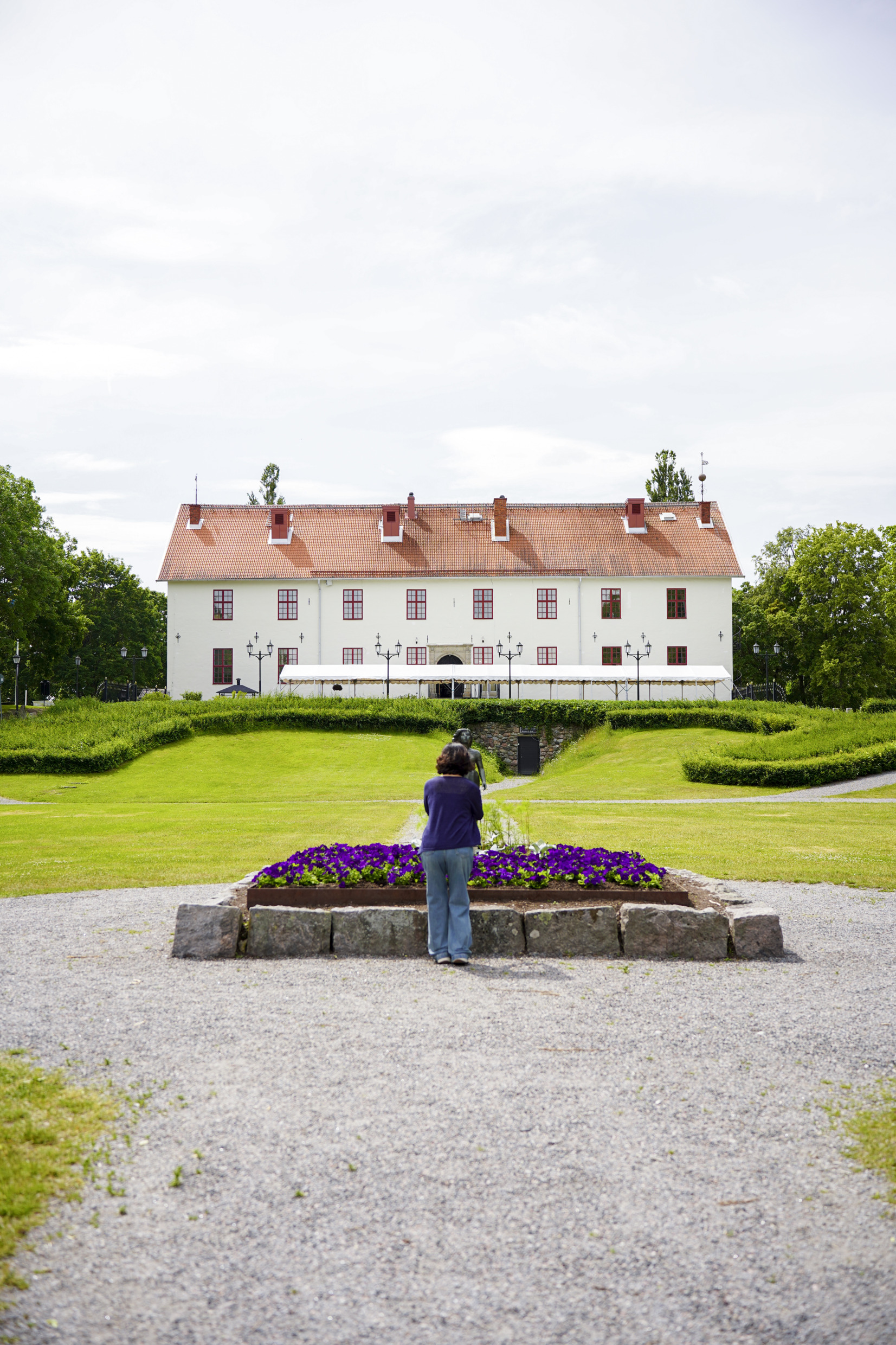Er staat een vrouw op de binnenplaats van kasteel Sunbyholm.