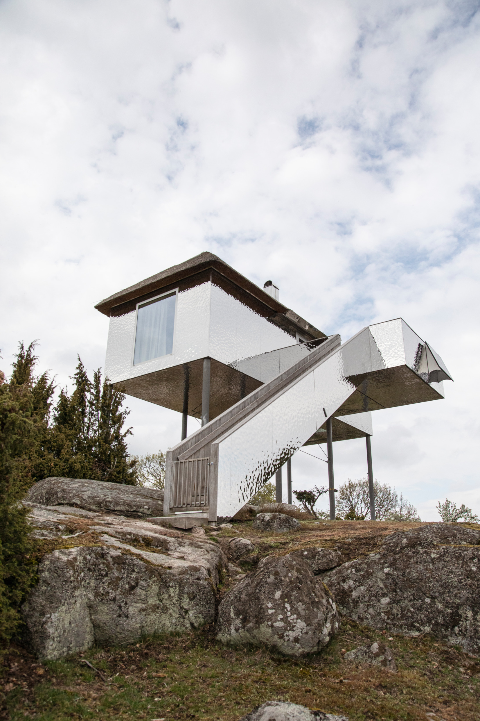 Exterior view of SynVillan glass villa at Eriksberg Hotel & Nature Reserve, surrounded by natural woodland and wildlife habitat in Blekinge.