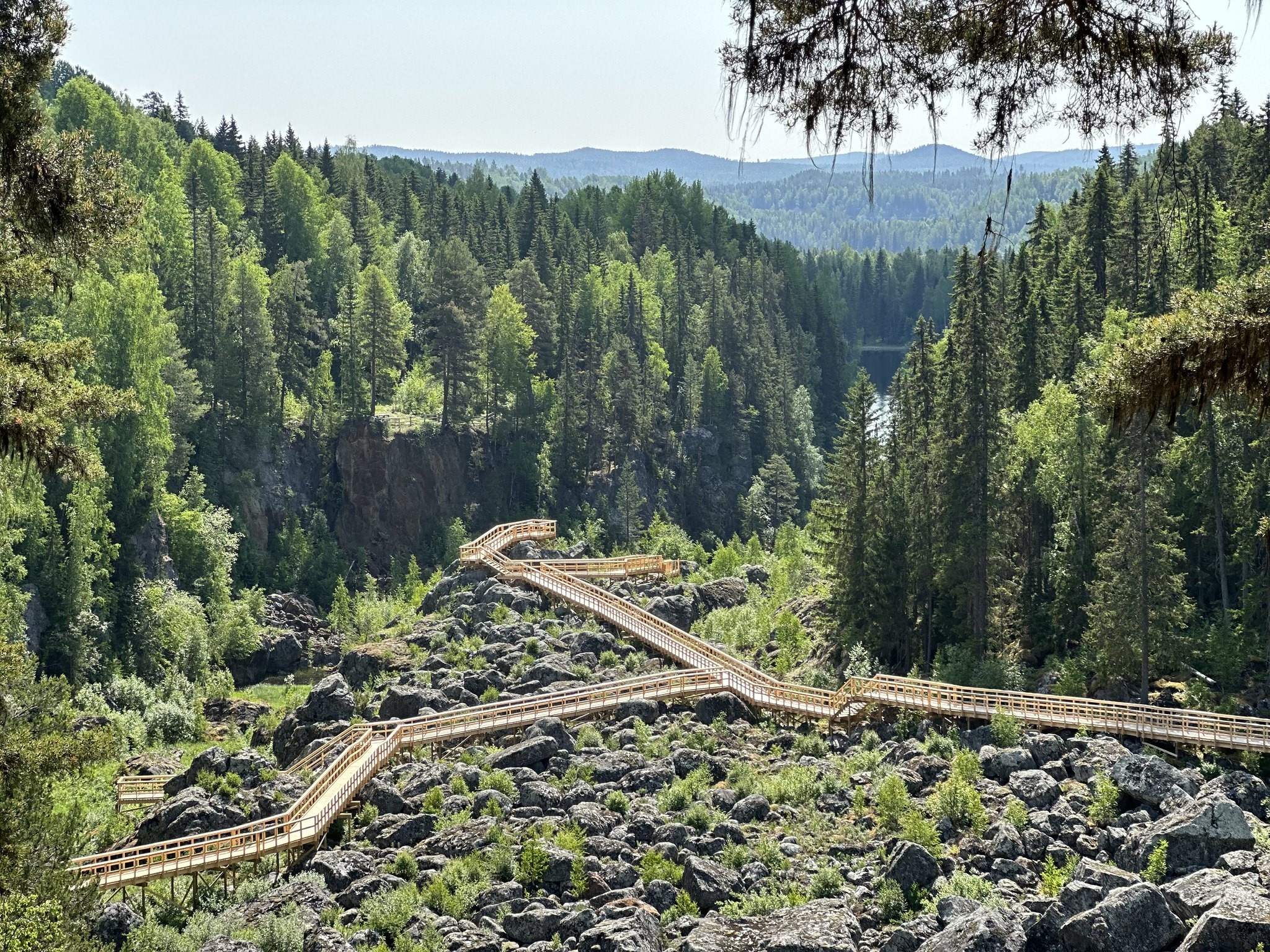 Uitzicht op de houten loopbruggen over het rotsachtige terrein bij Döda fallet in Ragunda, Zweden – een droge waterval die in 1796 per ongeluk leegliep en nu deel uitmaakt van Geopark Indalsälven.