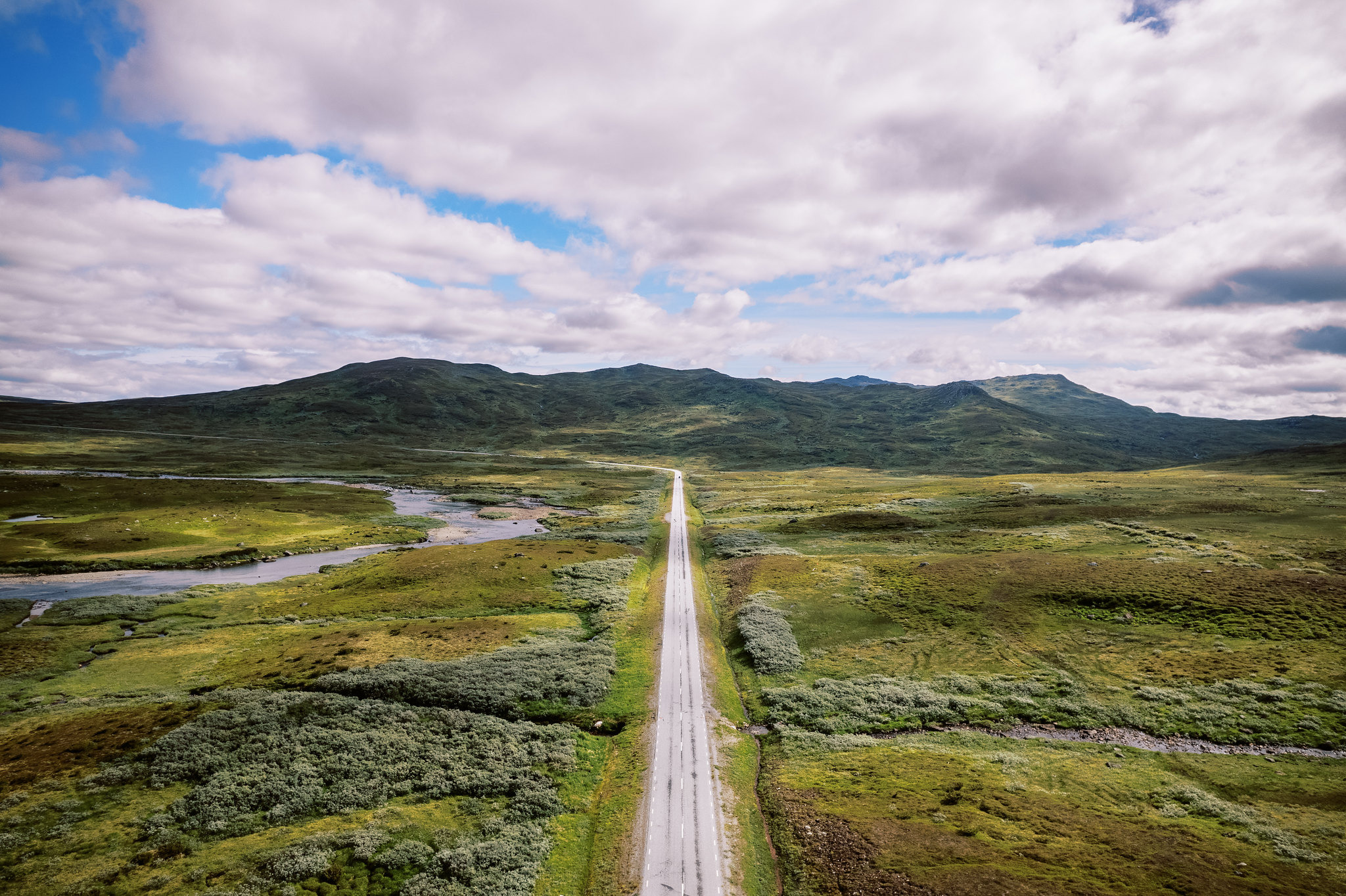 Luchtfoto van de Wildernisroute (Vildmarksvägen) die door open berglandschap loopt en langs rivieren kronkelt in Jämtland, in het noorden van Zweden.
