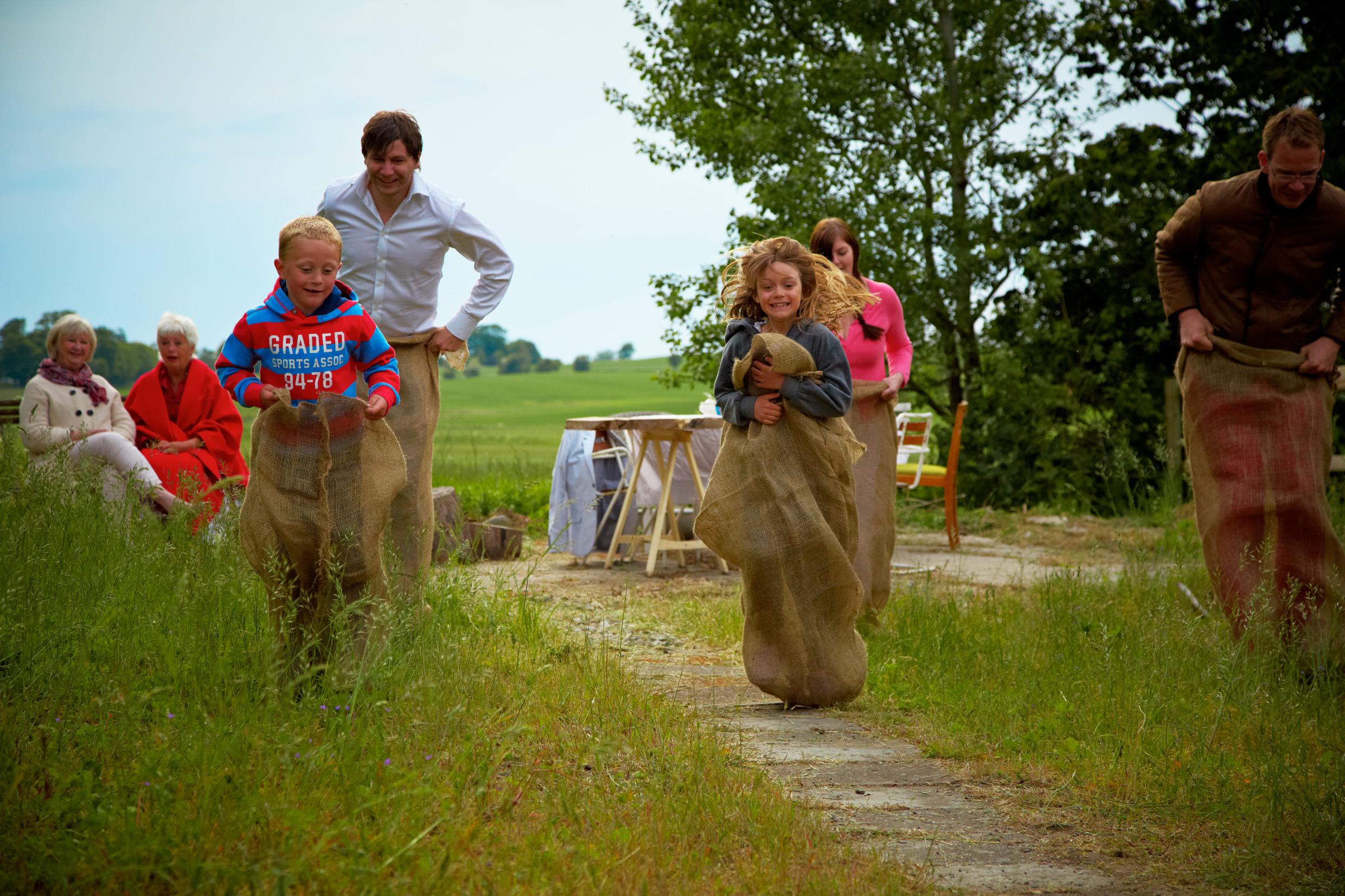 Kinderen en volwassenen doen aan zaklopen.