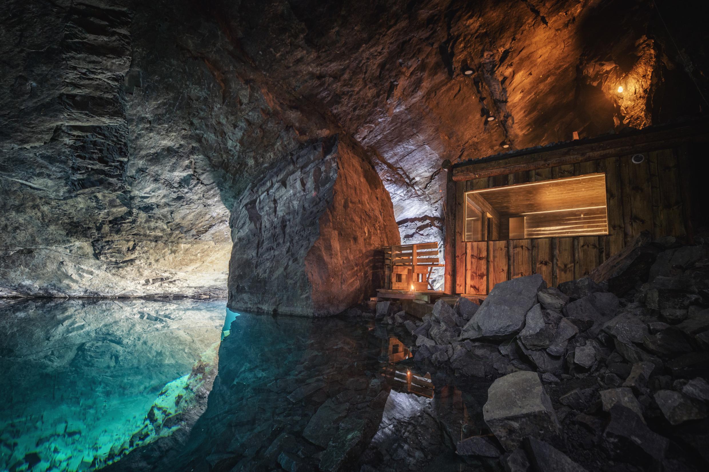Eine Holzsauna am blauen, klaren Wasser des Bergwerks der Adventure Mine in Dalarna.