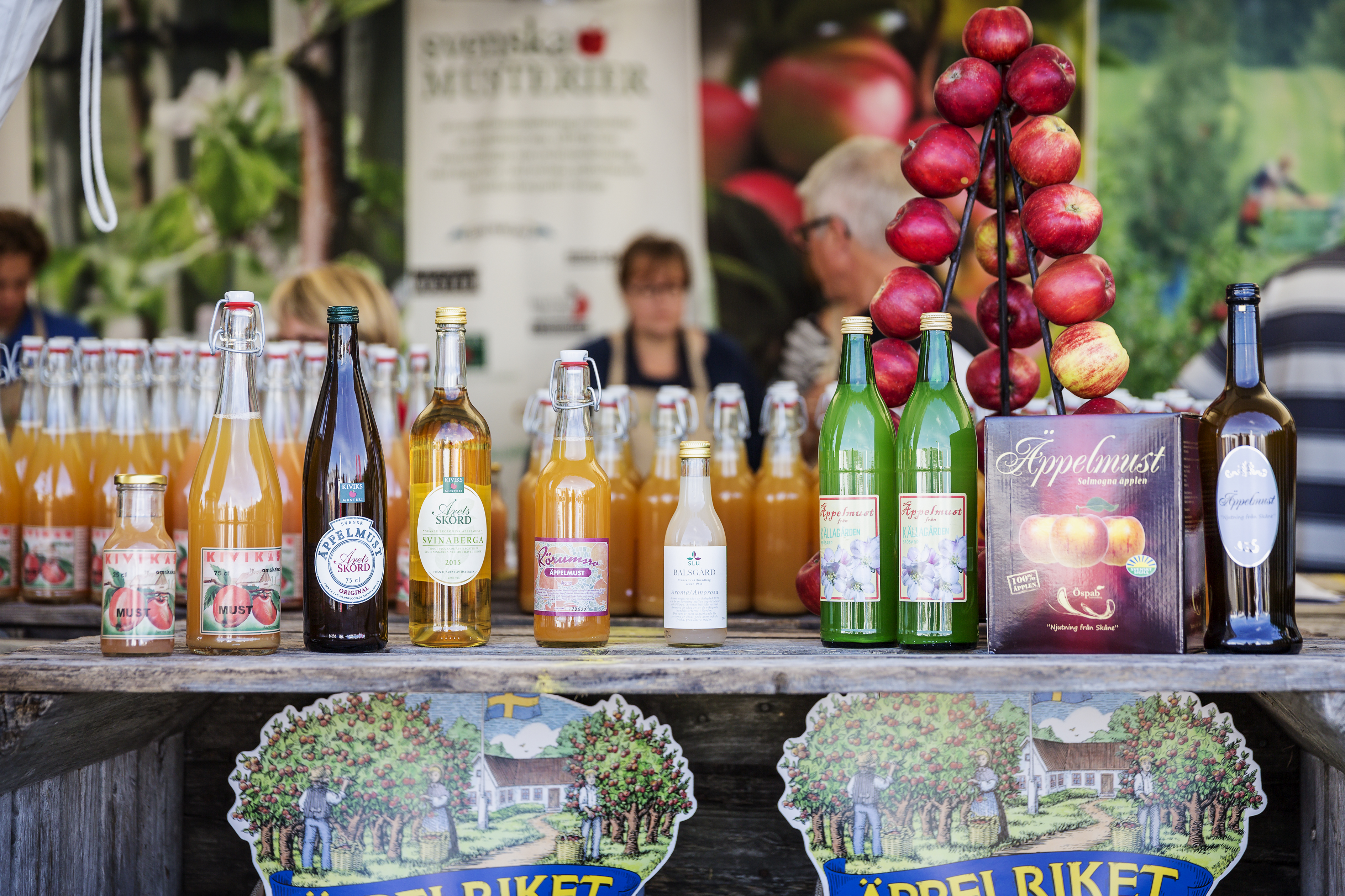 Flesjes appelsap en cider op een tafel.