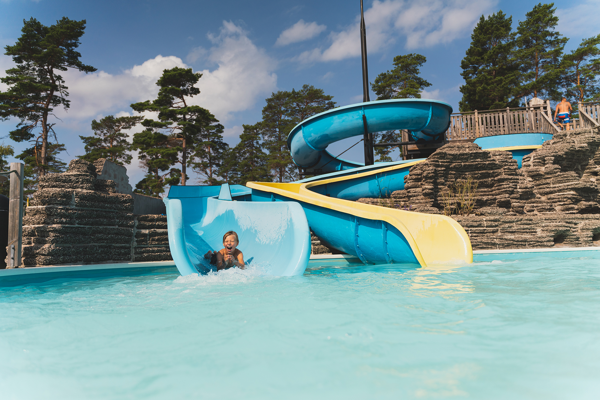 Child going down a water slide into a pool at Böda Sand Beach Resort on Öland.