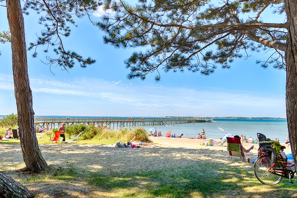 Mensen ontspannen op een strand tijdens een zonnige dag.