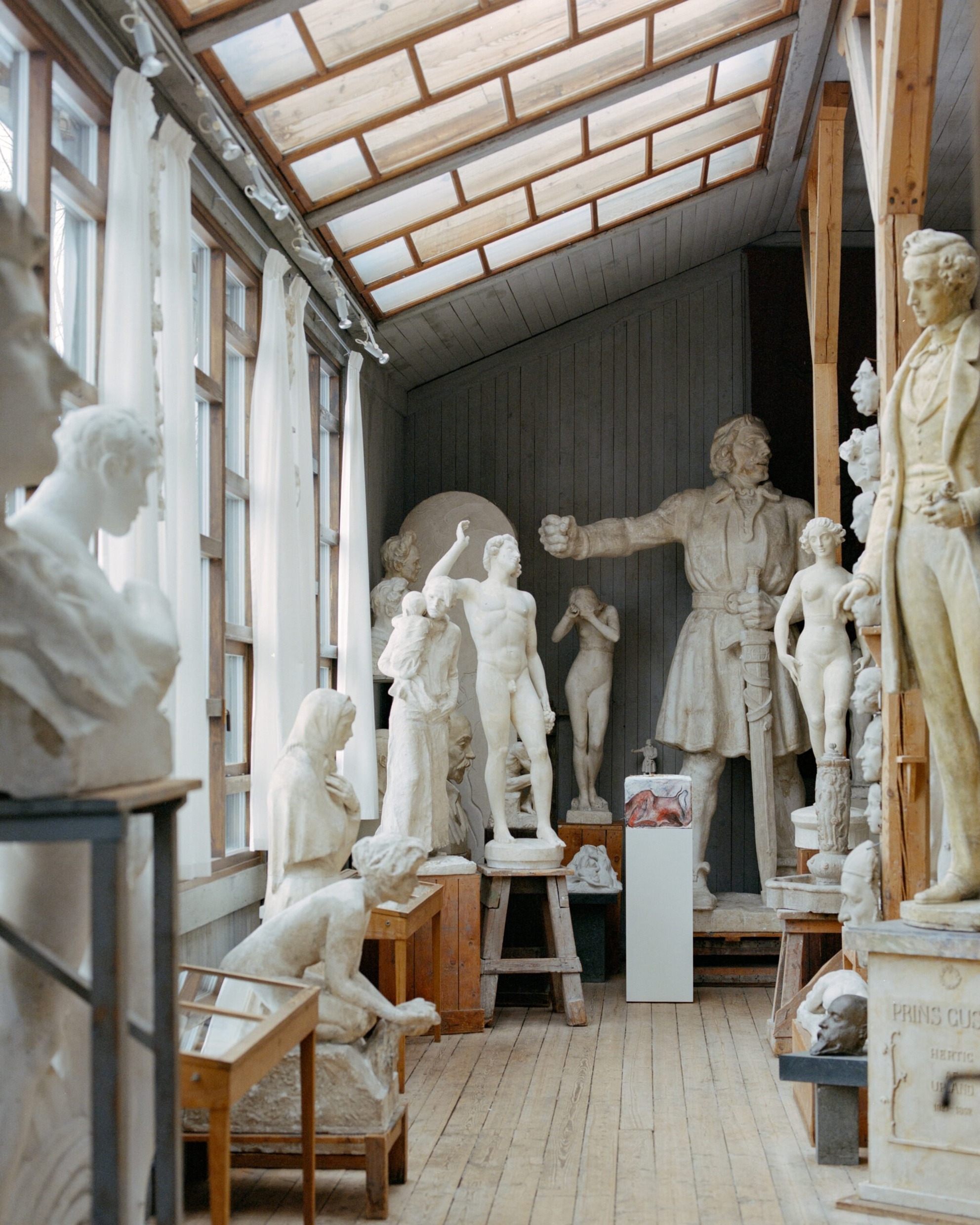 L'intérieur du musée Carl Eldh Studio à Stockholm, avec une salle ensoleillée remplie de sculptures en plâtre blanc et de planchers en bois.