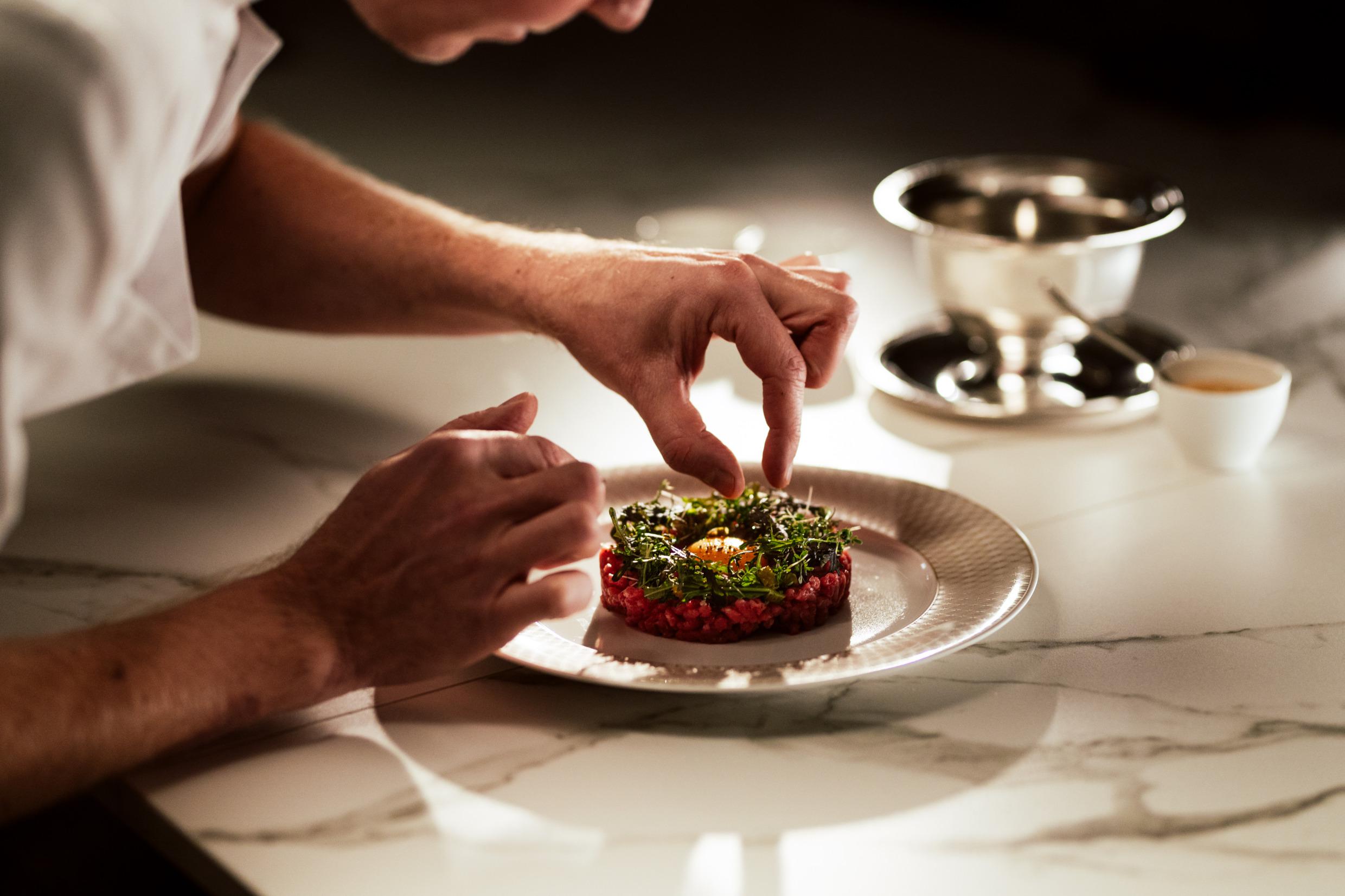 Een kok dresseert een bordje.