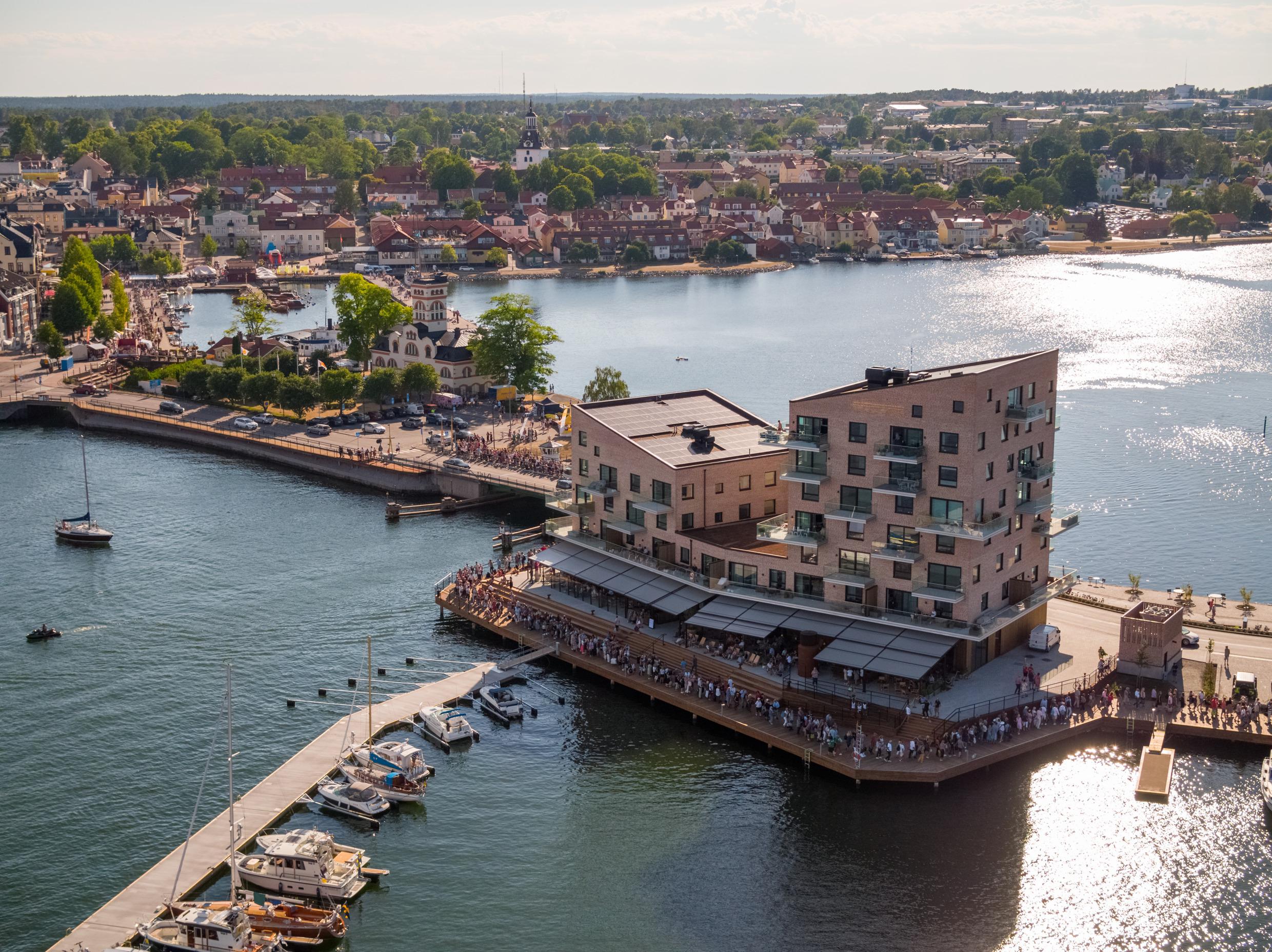 Het hotel Slottsholmen en het grote terras, omgeven door water en gelegen aan een kleine haven.