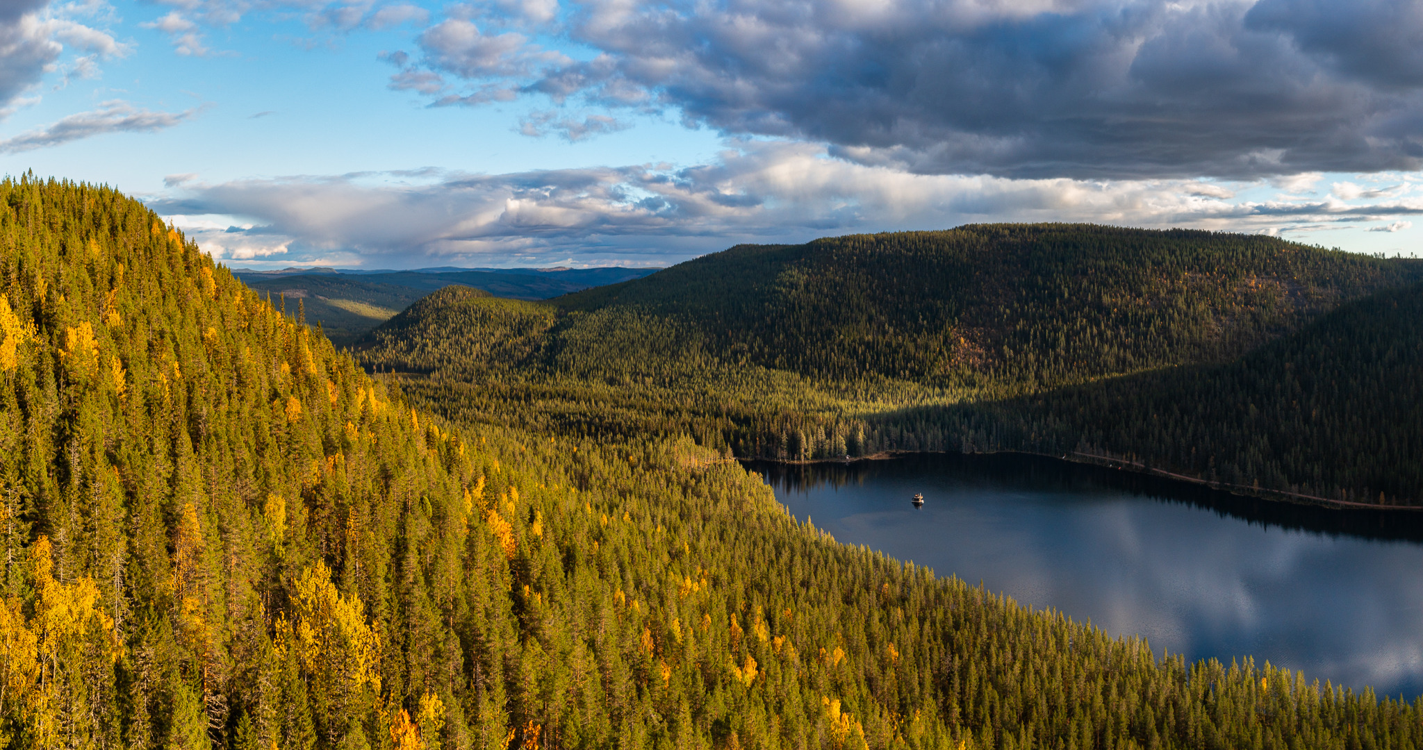 Luchtfoto van de drijvende hut Raven op een meer, omringd door dicht herfstbos in Midden-Zweden.