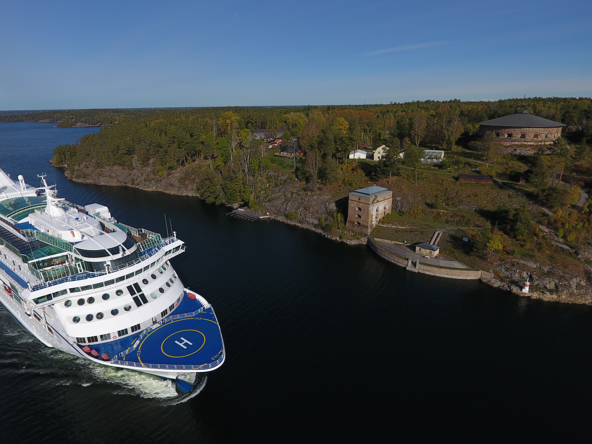 Fredriksborg Fortress by Oxdjupet inlet, sunny day, cruise ship passing by