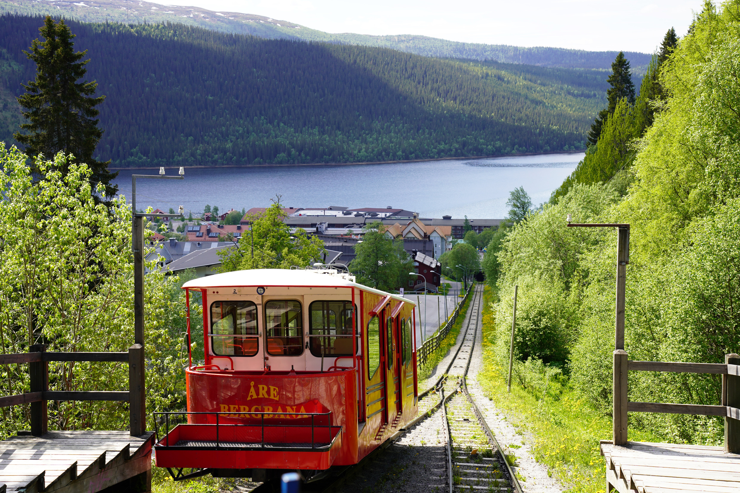 Het uitzicht vanaf de kabelbaan in Åre in de zomer. Een rode kabelbaan is op weg naar beneden.