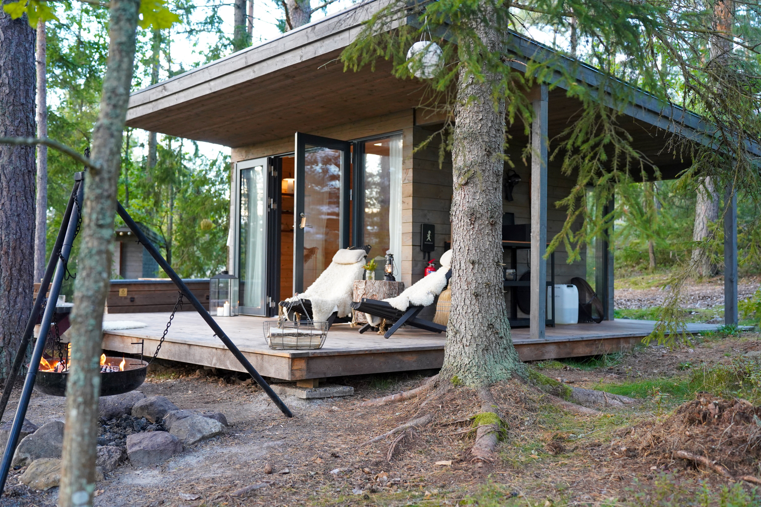 Een hotelkamer met een buitenterras met twee stoelen. De kamer is omgeven door de natuur.