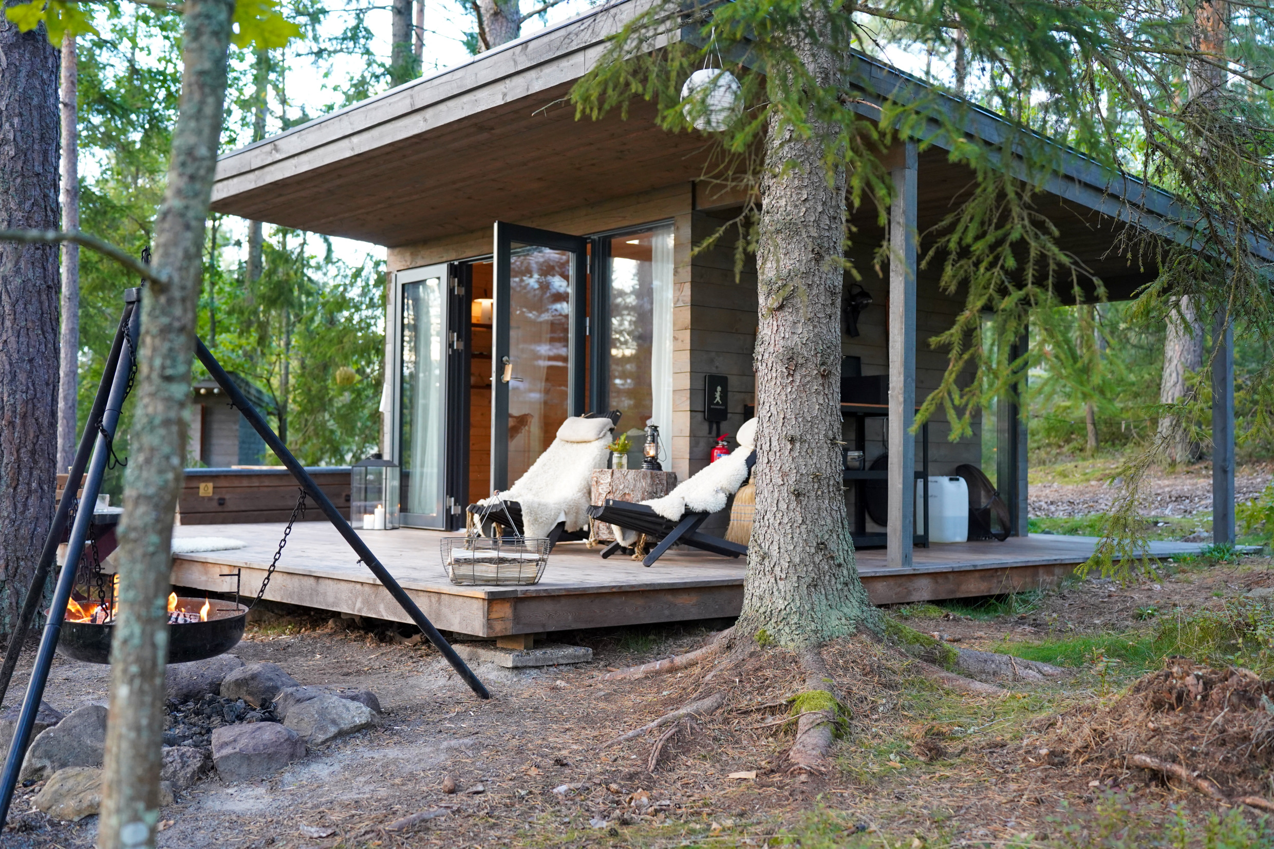 Een hotelkamer met een terras met twee stoelen. De kamer ligt midden in de natuur.