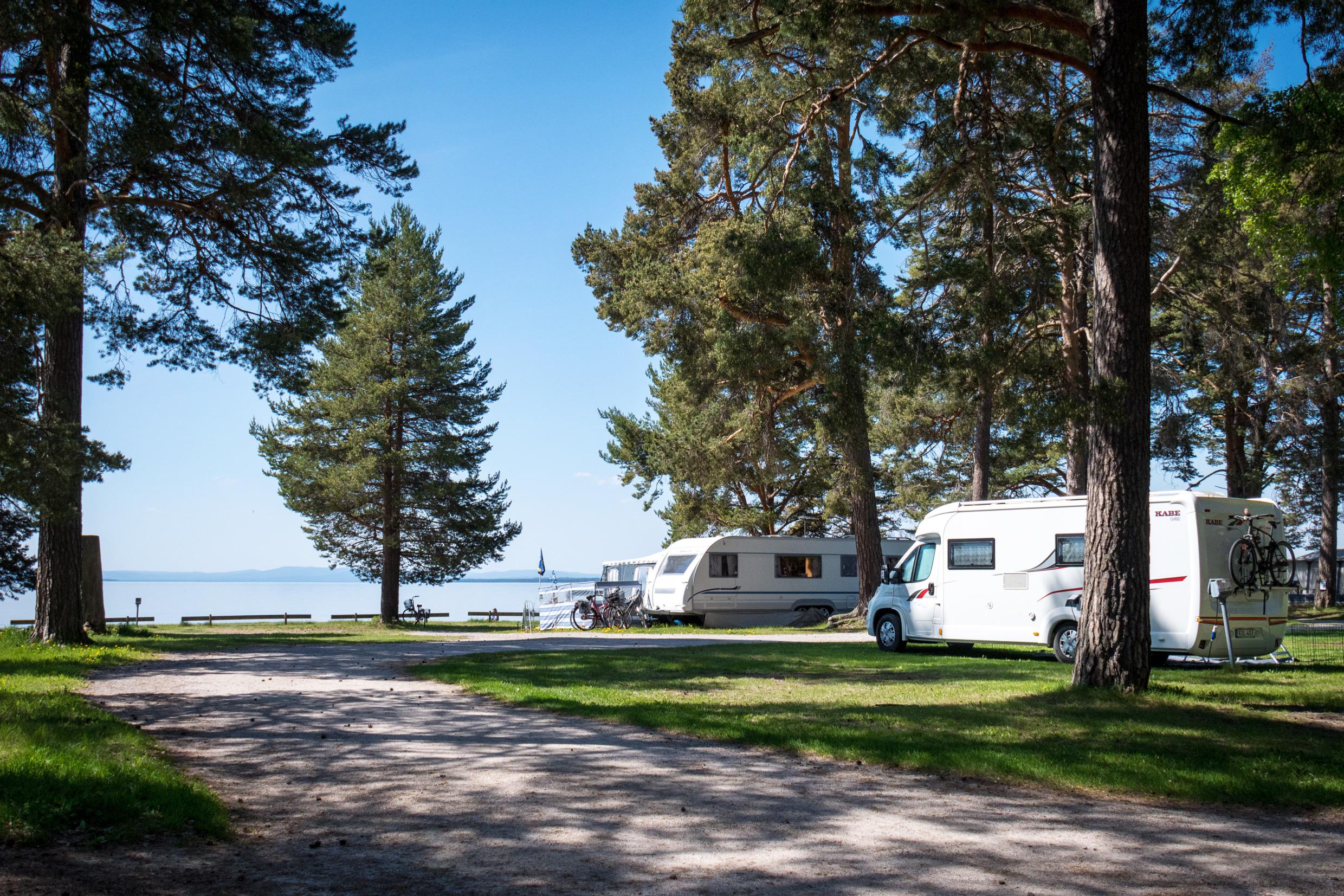 Een camper en een caravan op een camping aan het Siljanmeer.