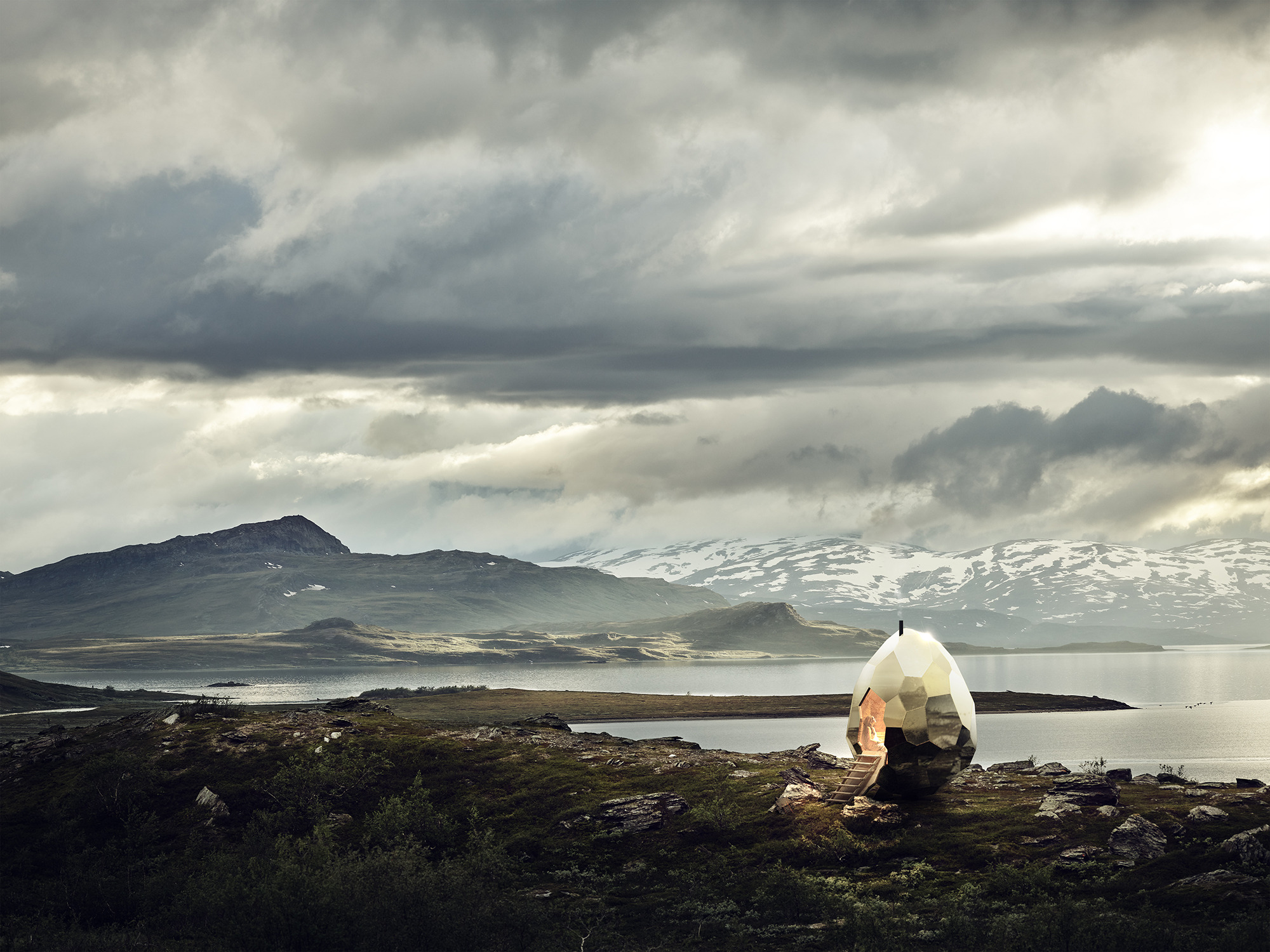 The Solar Egg sauna set on a scenic hillside overlooking a lake and mountains, under dramatic cloudy skies in Swedish Lapland.