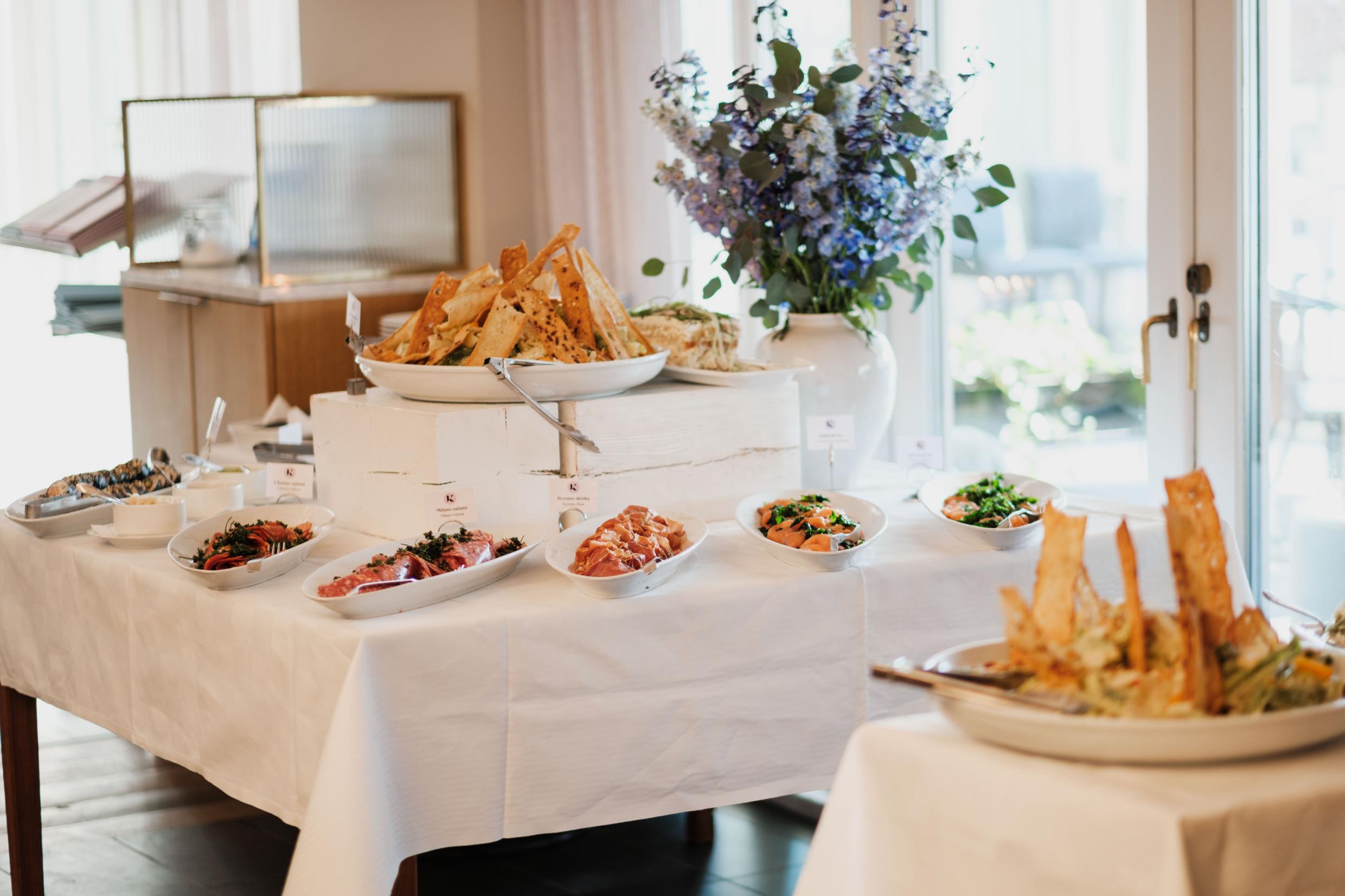 Un brunch sous forme de buffet disposé sur des tables avec des nappes blanches.