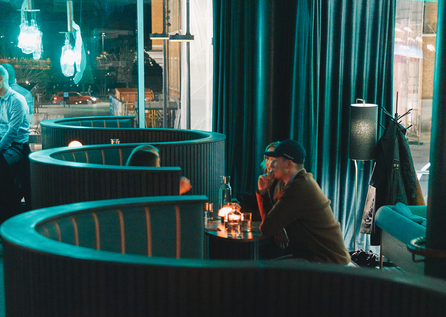 Guests enjoying drinks inside Facit Bar in Umeå, a stylish cocktail bar with softly lit booths.