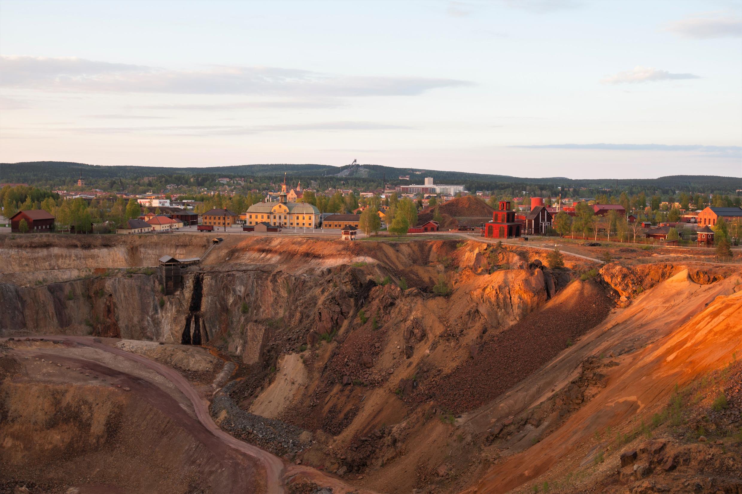 Vue aérienne de la mine de Falun et de ses environs avec quelques maisons et des collines verdoyantes à l'horizon.