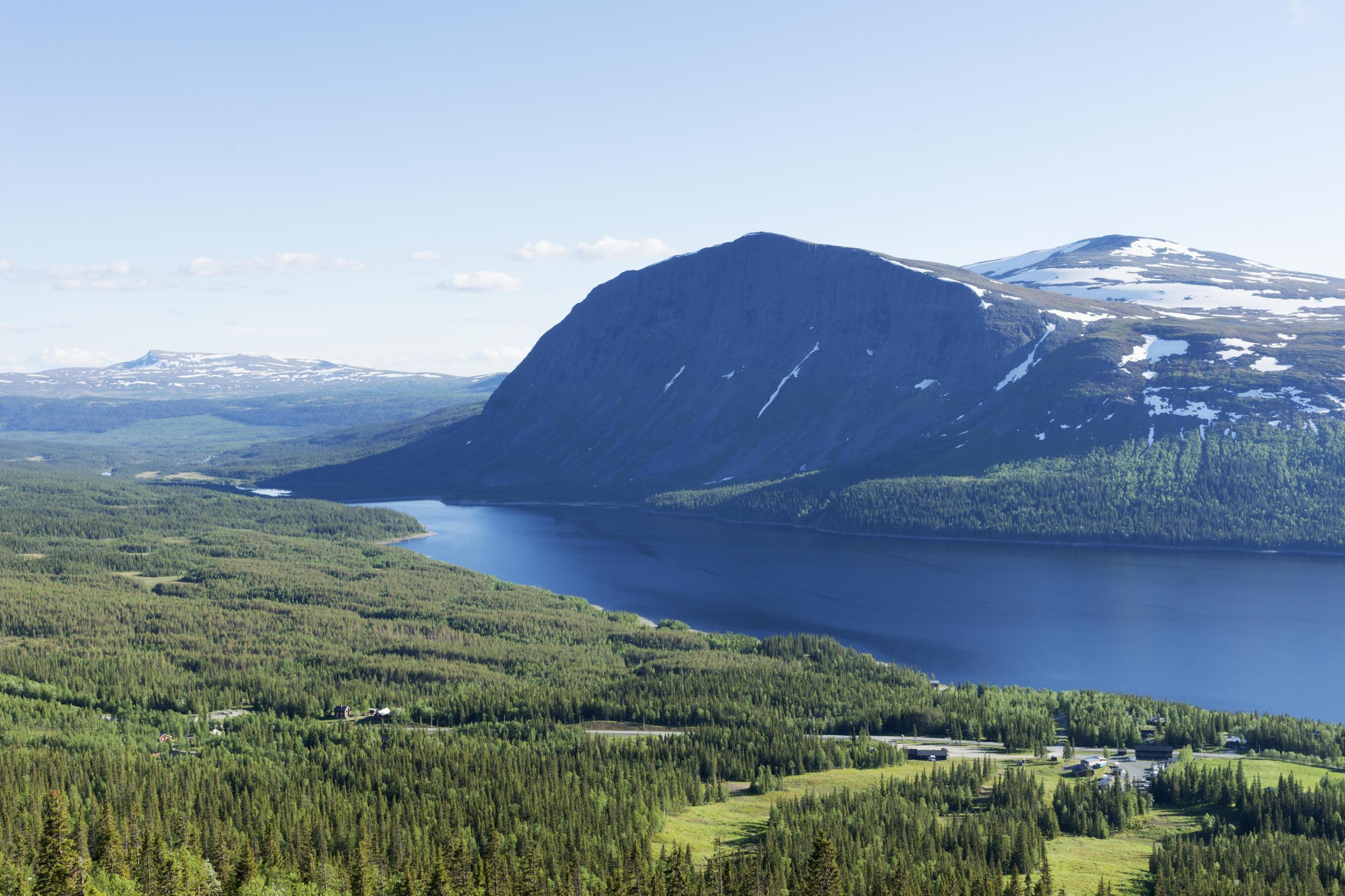 Ein malerischer Blick auf einen Wald, einen Fluss und einen Berg, die Teil der Natur von Västerbotten sind.
