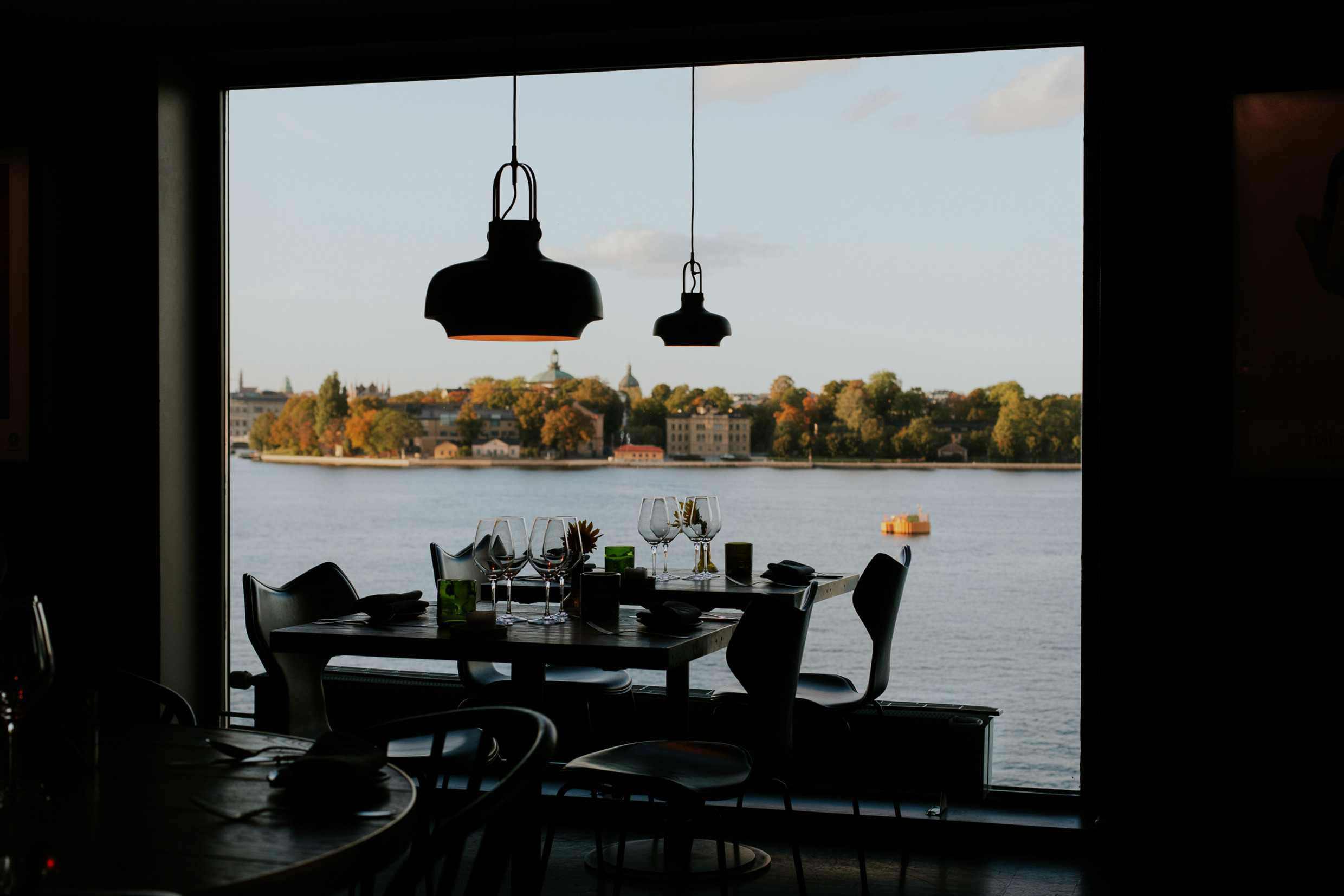 Een gedekte tafel voor het diner in het restaurant van Fotografiska in Stockholm, met uitzicht op het water en Djurgården.