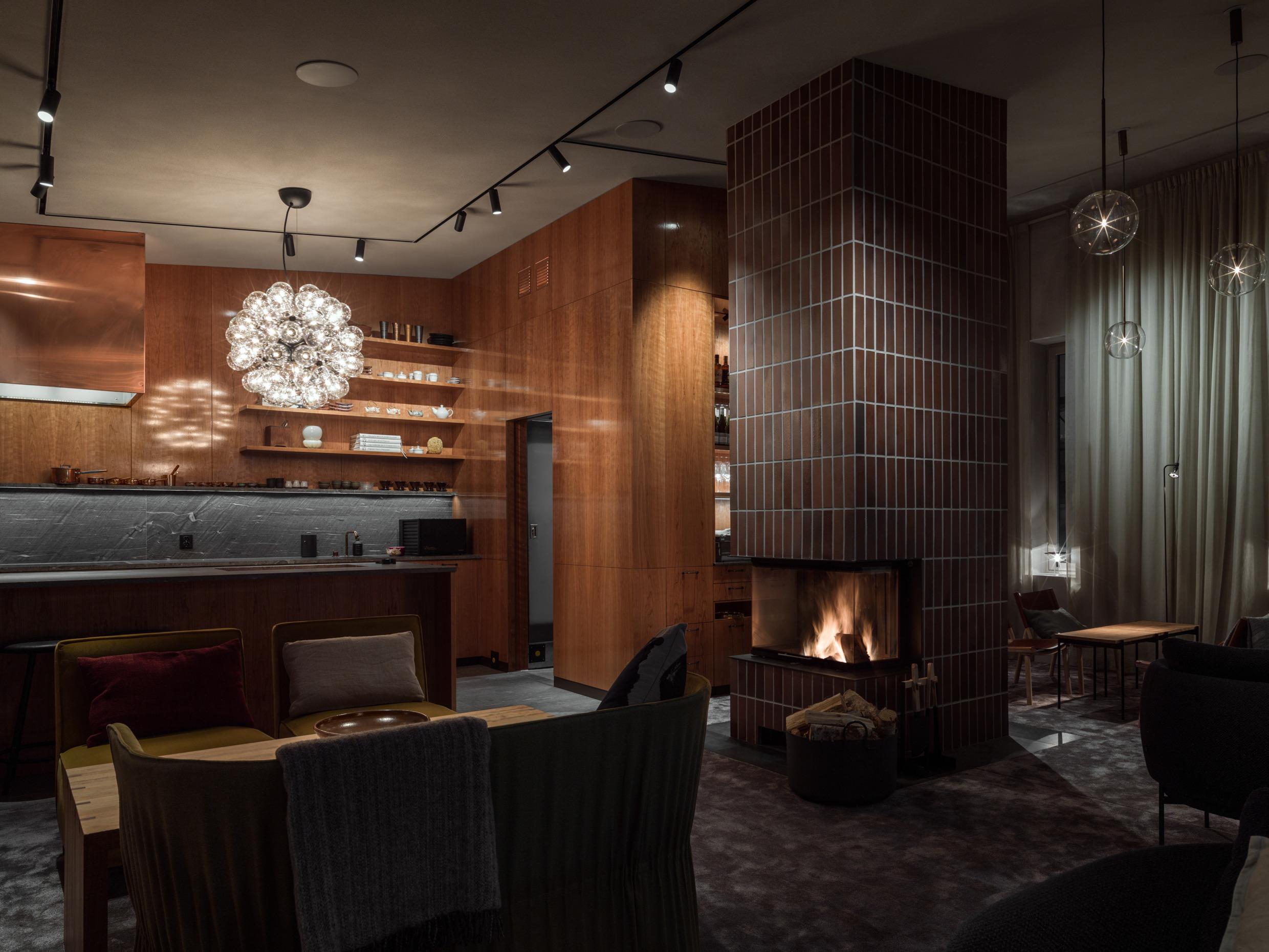 Das Innere des Stockholmer Restaurants Frantzén mit Holztischen und einem Holzkamin.