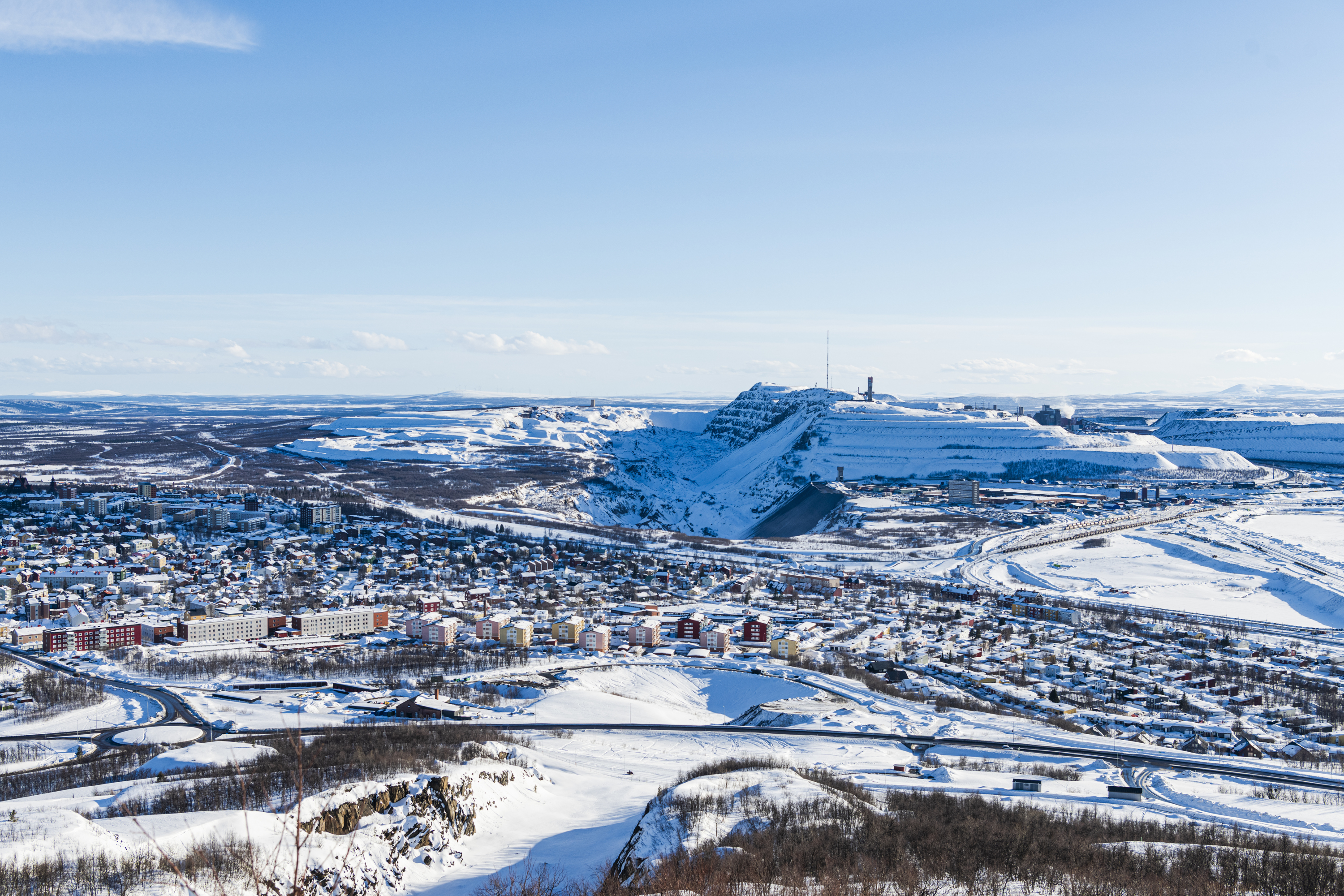 Het met sneeuw bedekte Kiruna, gezien vanuit de lucht, met de grote open ijzerertsmijn en het omringende arctische landschap.