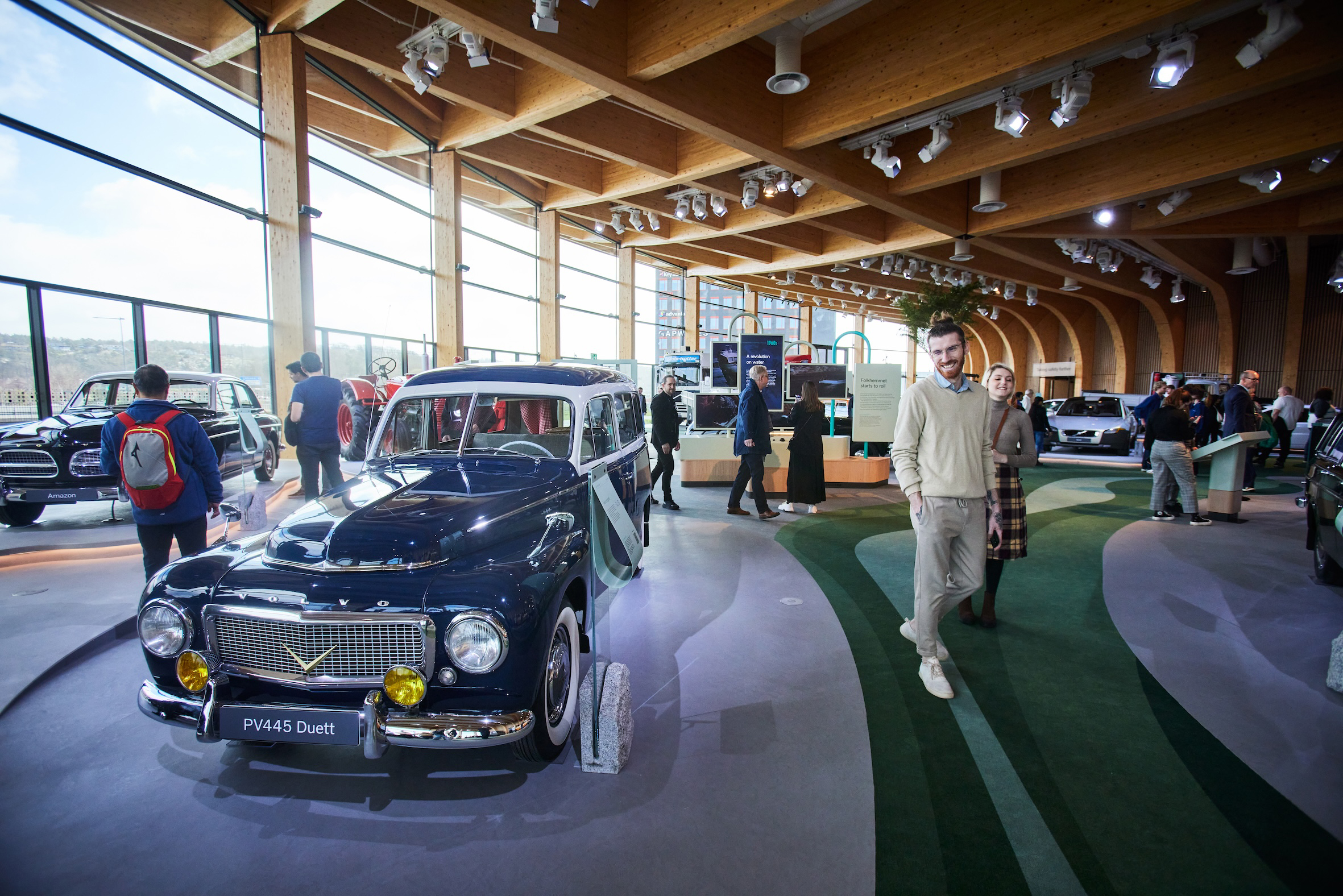 Visitors exploring classic Volvo vehicles and exhibitions inside World of Volvo in Gothenburg.