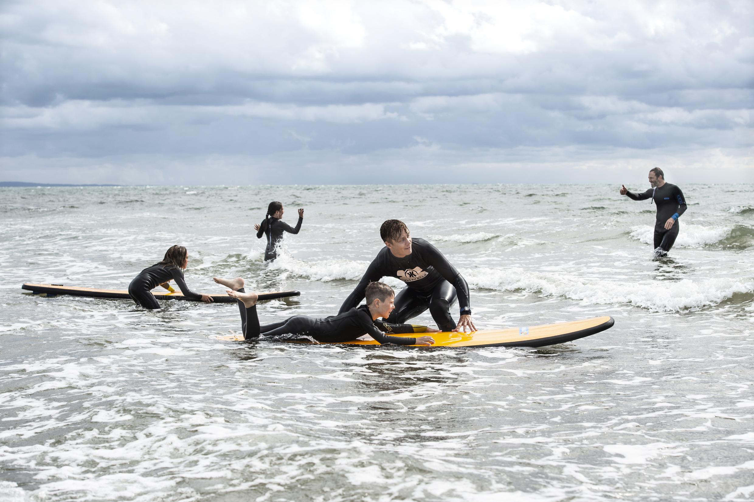 Eine Person surft am Strand in Halland.