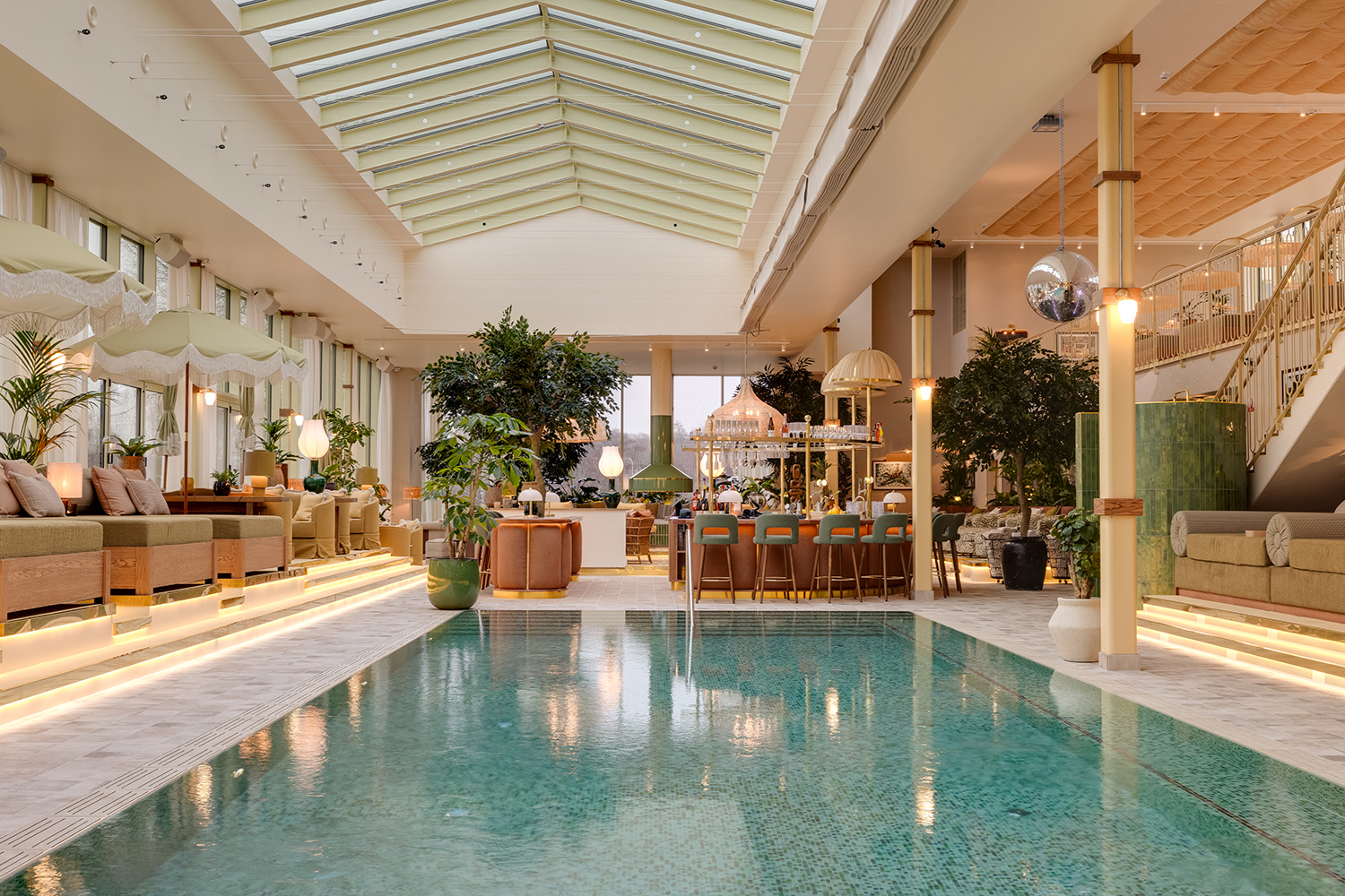 Hallenbad und Loungebereich im Hjortviken Country Club, umgeben von viel Grün und modernem skandinavischem Design.