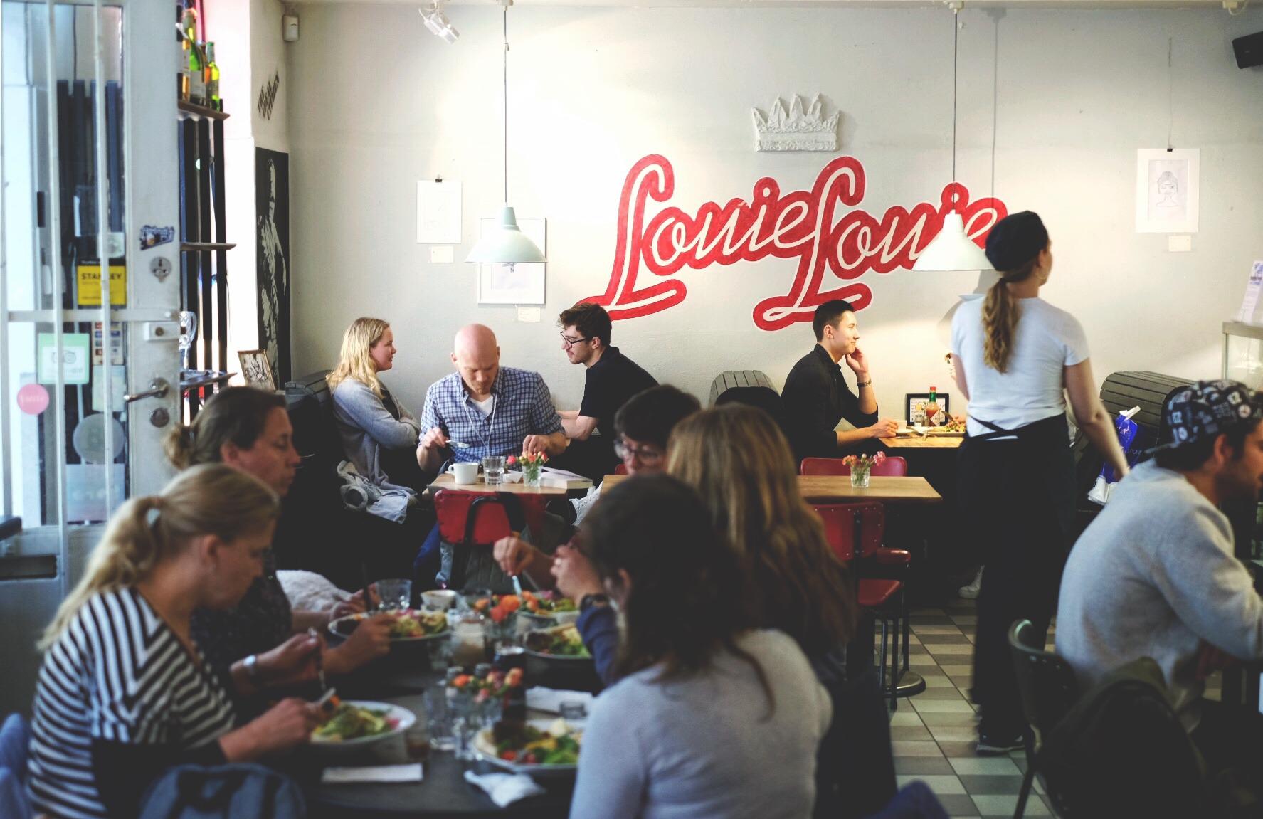 Des clients assis à des tables chez Louie Louie.