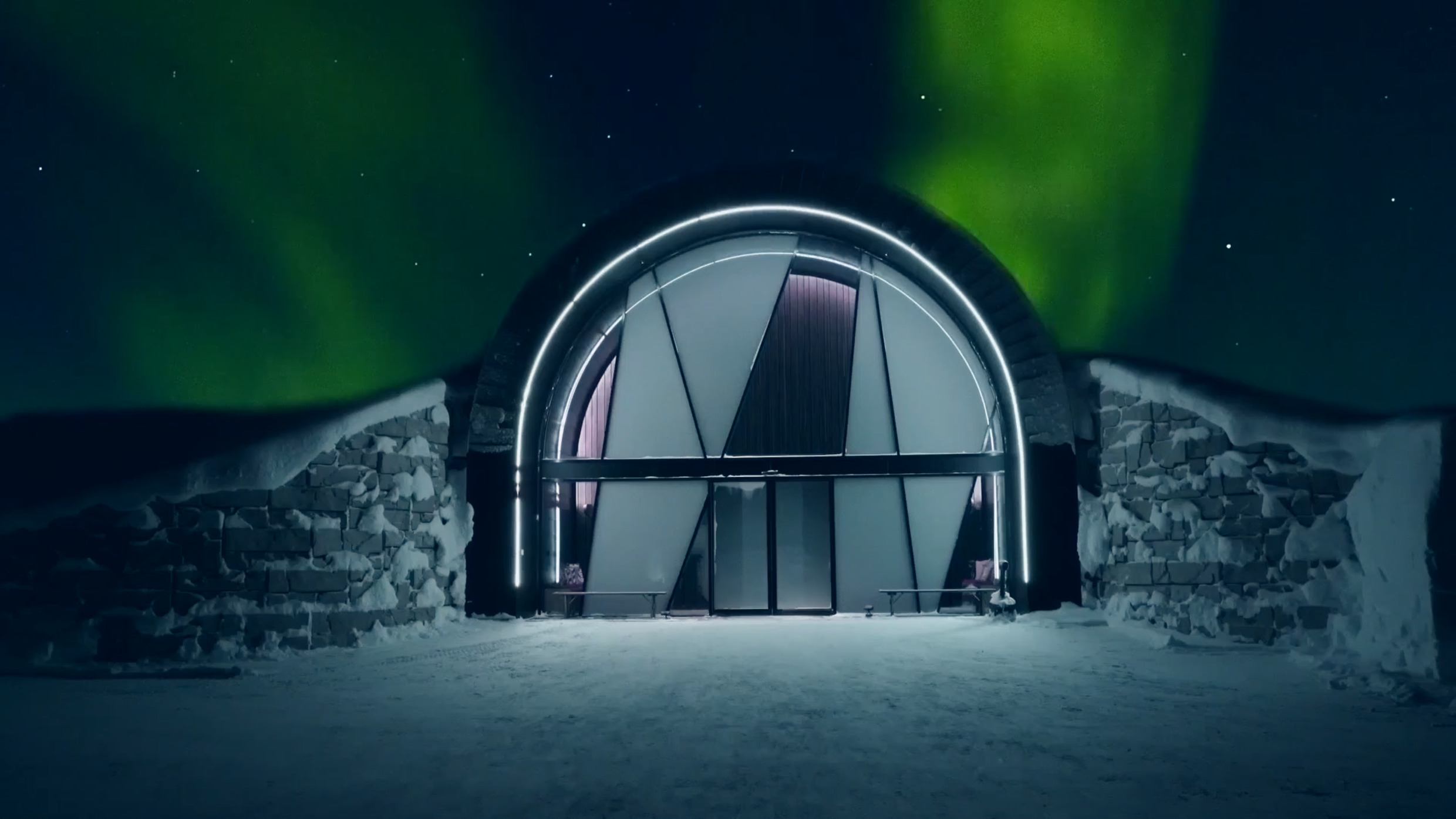 Boven de ingang van het Icehotel schittert het groene noorderlicht.