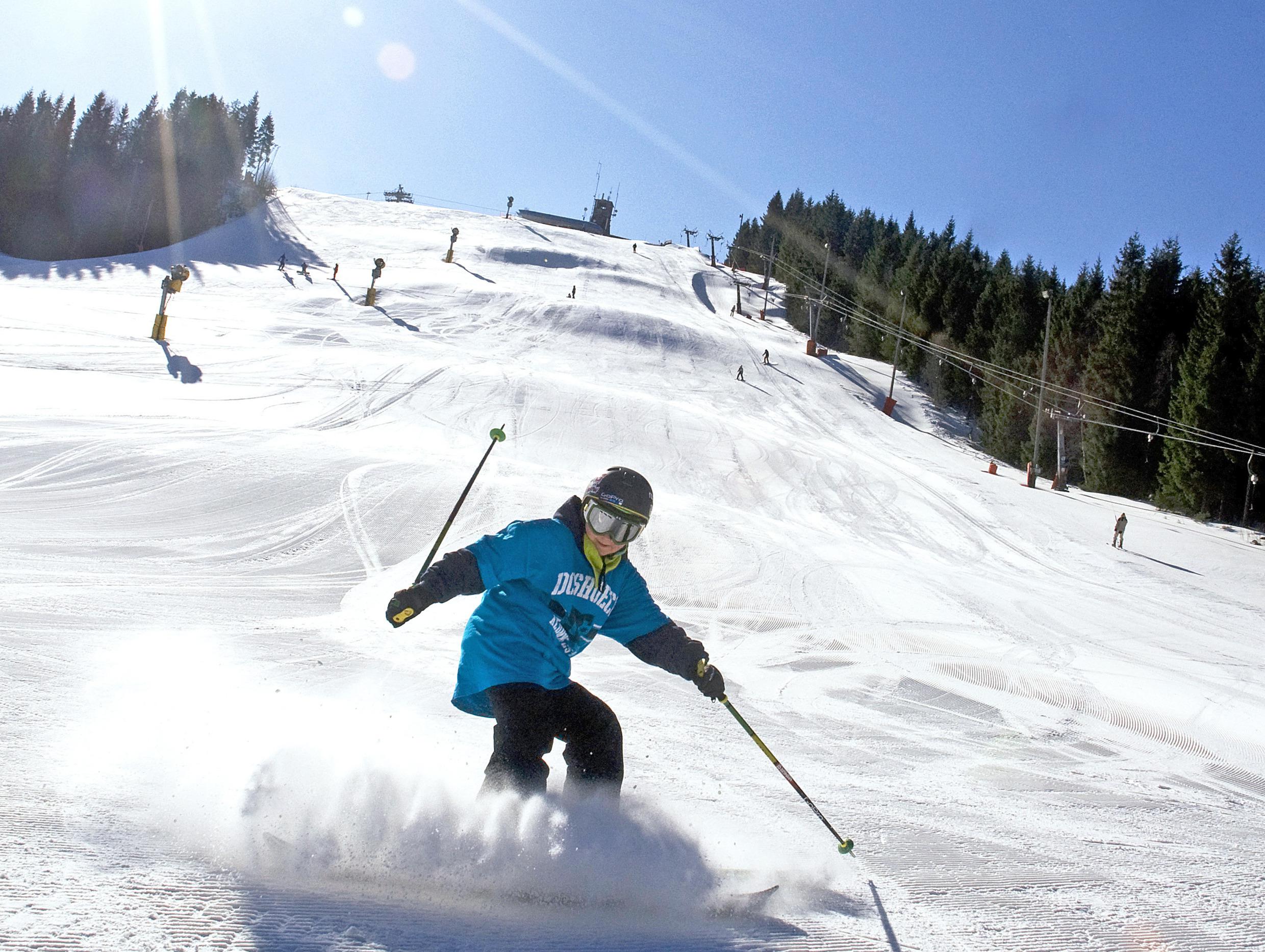 Ein Kind fährt im familienfreundlichen Skigebiet Isaberg in Småland die Piste mit Skiern hinunter.