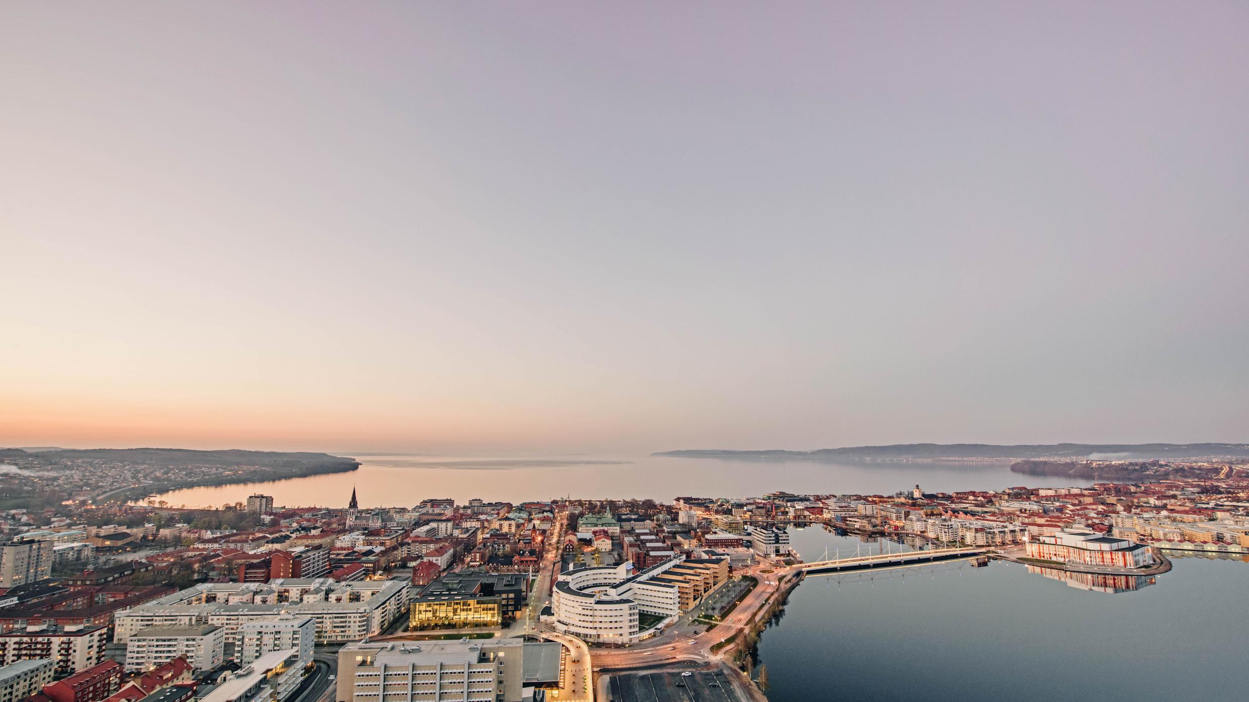 Luftaufnahme der Stadt Jönköping und eines großen Sees in der Abenddämmerung.