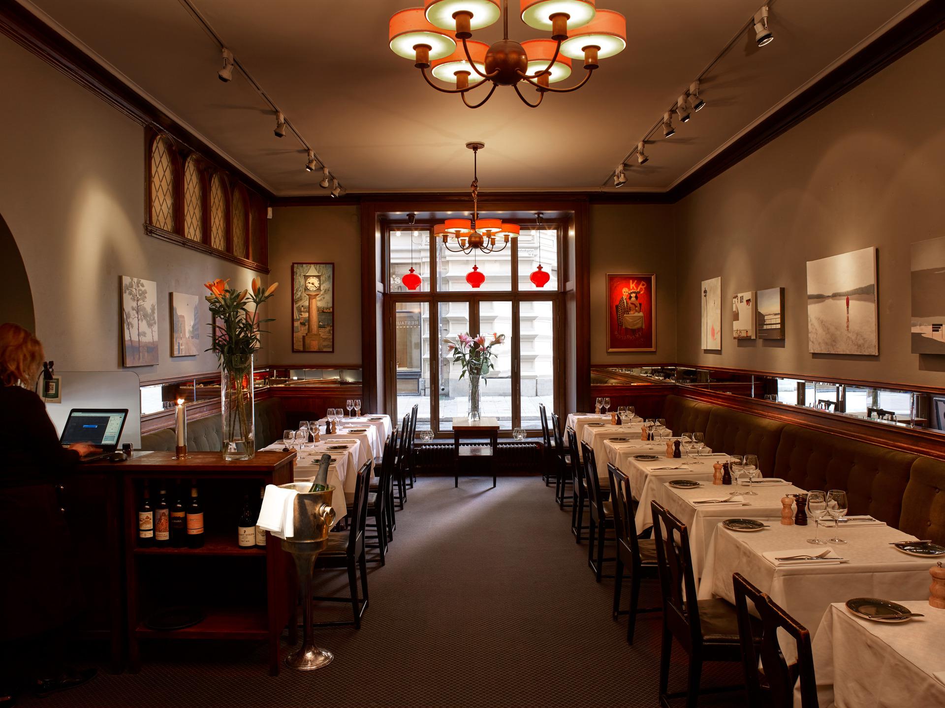 Das Restaurant Konstnärsbaren, mit Gemälden an den Wänden und weißen Tüchern auf den Tischen.