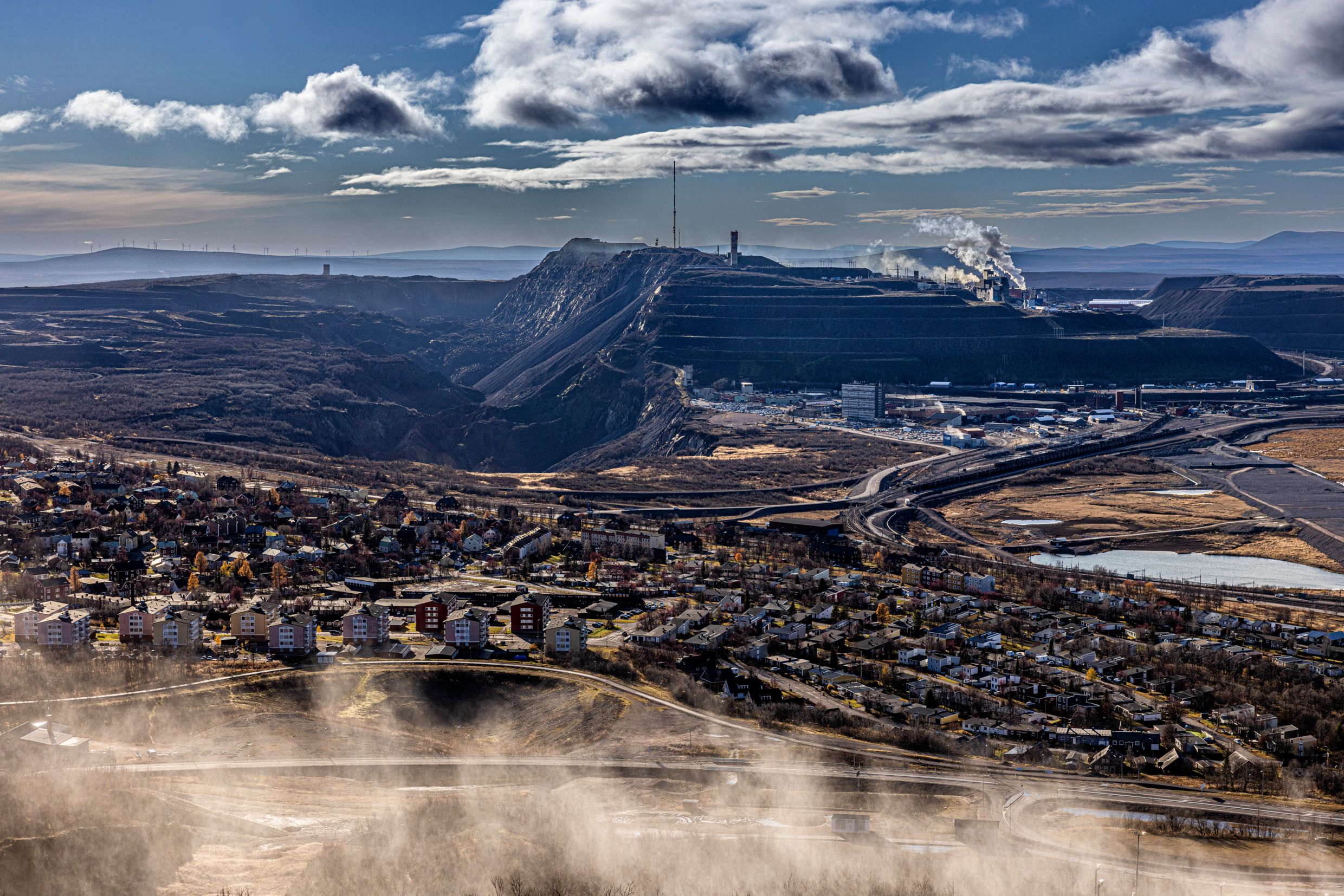Skyline van een stad met een grote mijn op de achtergrond.