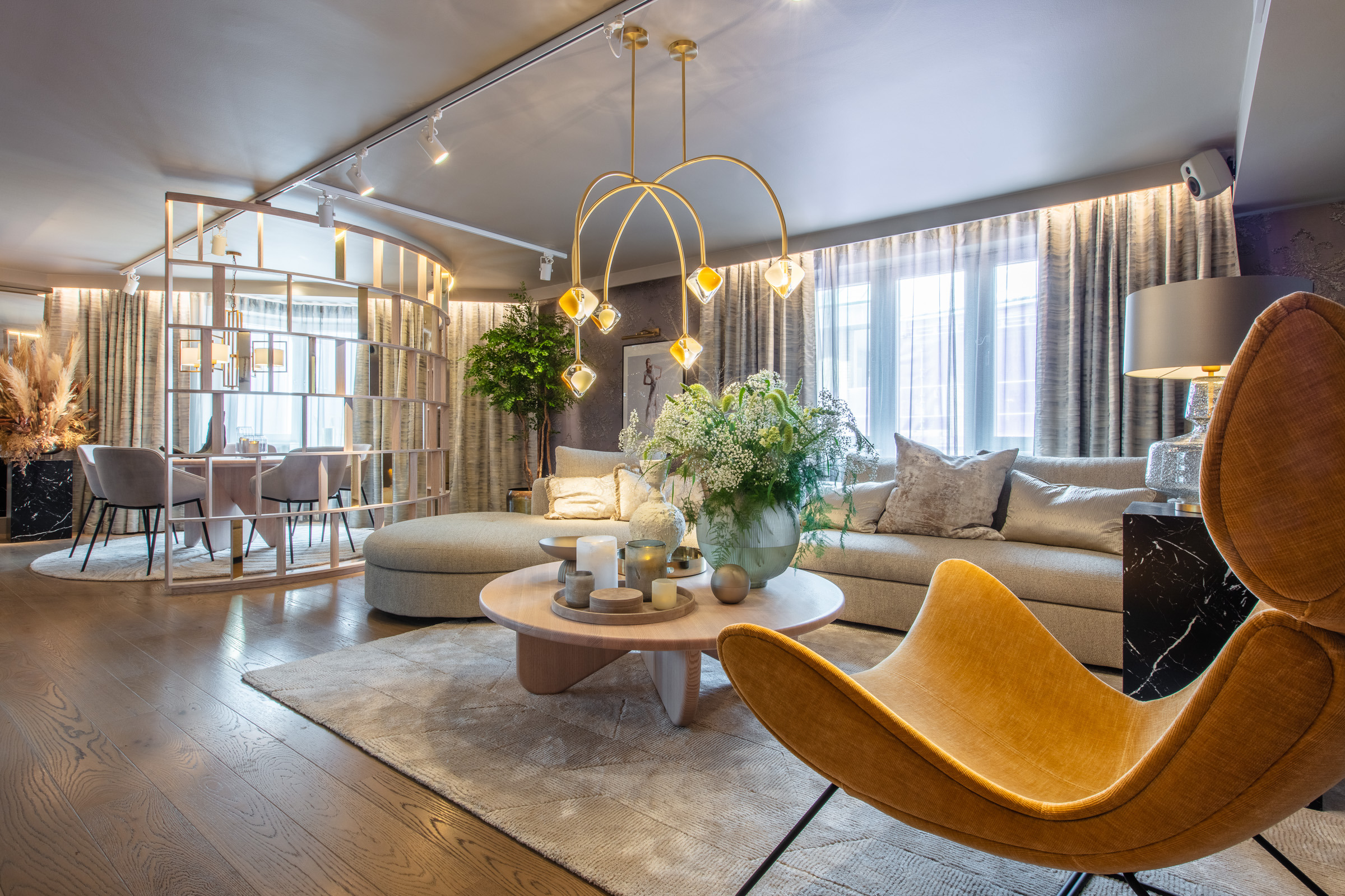 Elegante Lars Wallin-suite bij Radisson Blu Scandinavia in Göteborg, met lichte kleuren, gouden accenten, een corduroy fauteuil en weelderige groene planten.