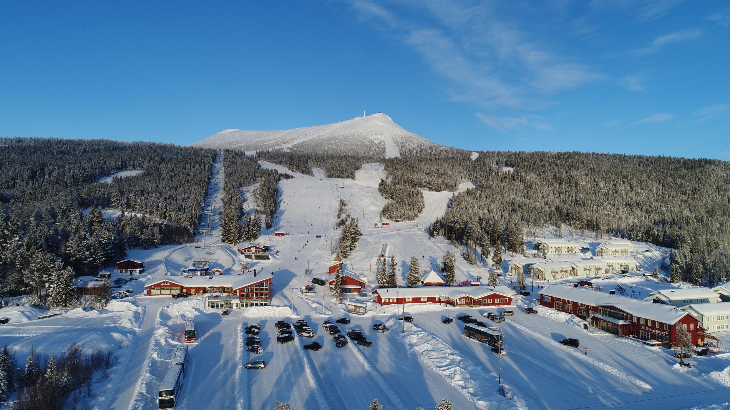 A ski resort with red houses and snow covered slopes.