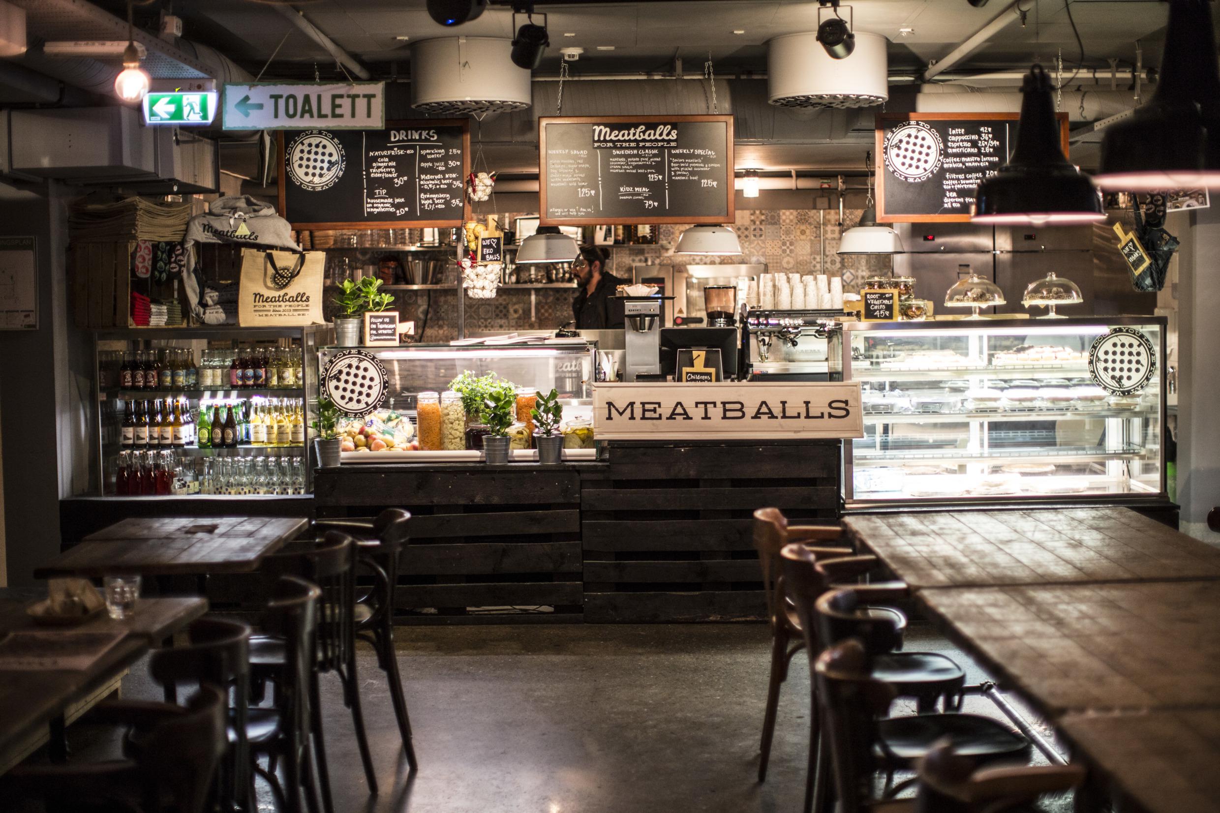 Le comptoir d'un restaurant vide à Stockholm, avec un grand panneau indiquant 'Meatballs'.