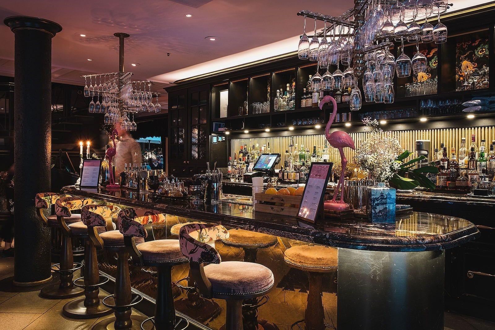 Un bar décoré avec verres, shakers, serviettes et autres accessoires.