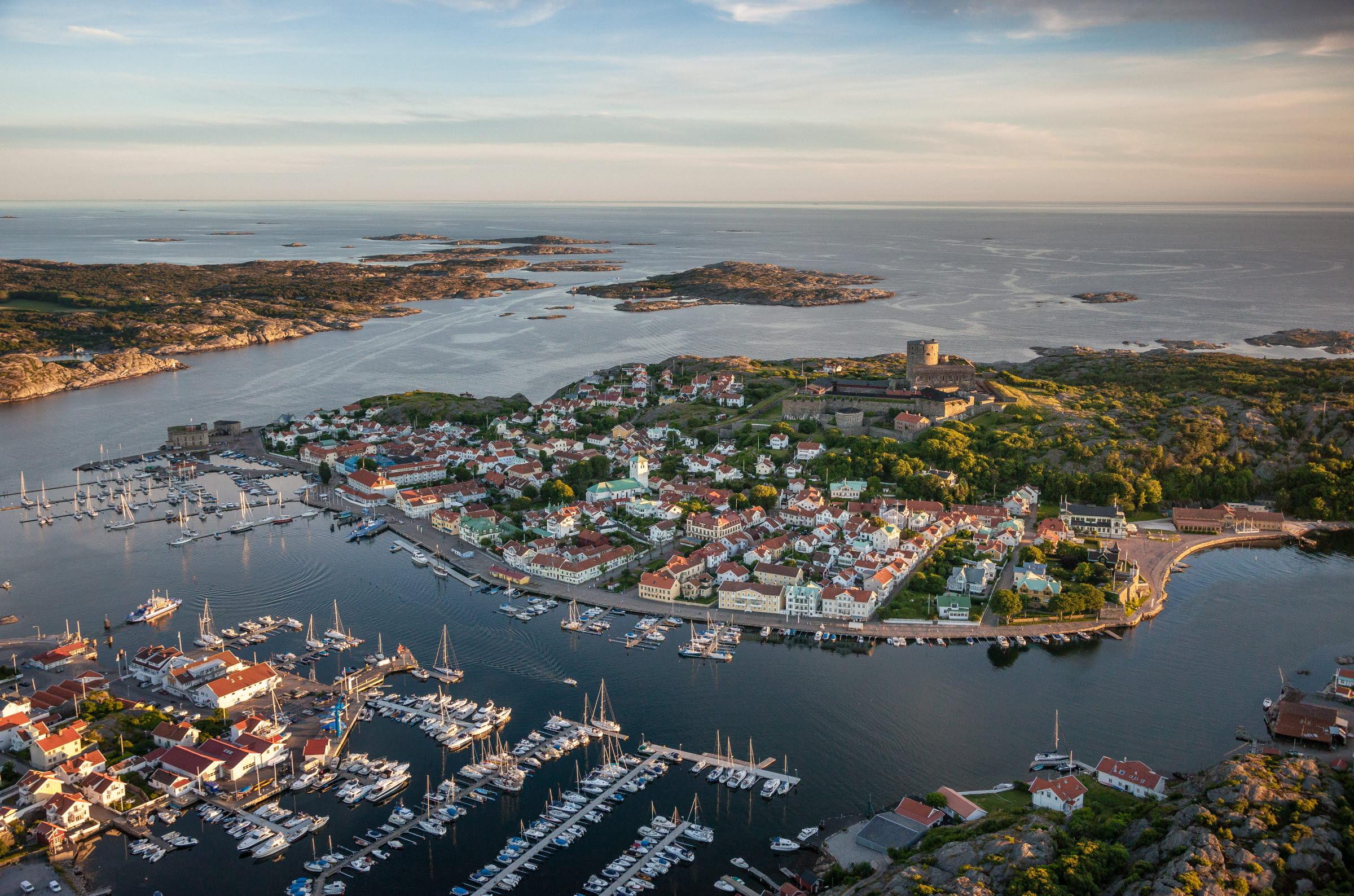 Luchtfoto van het stadje Marstrand met zeilboten op de voorgrond, het fort in het midden en de archipel op de achtergrond.