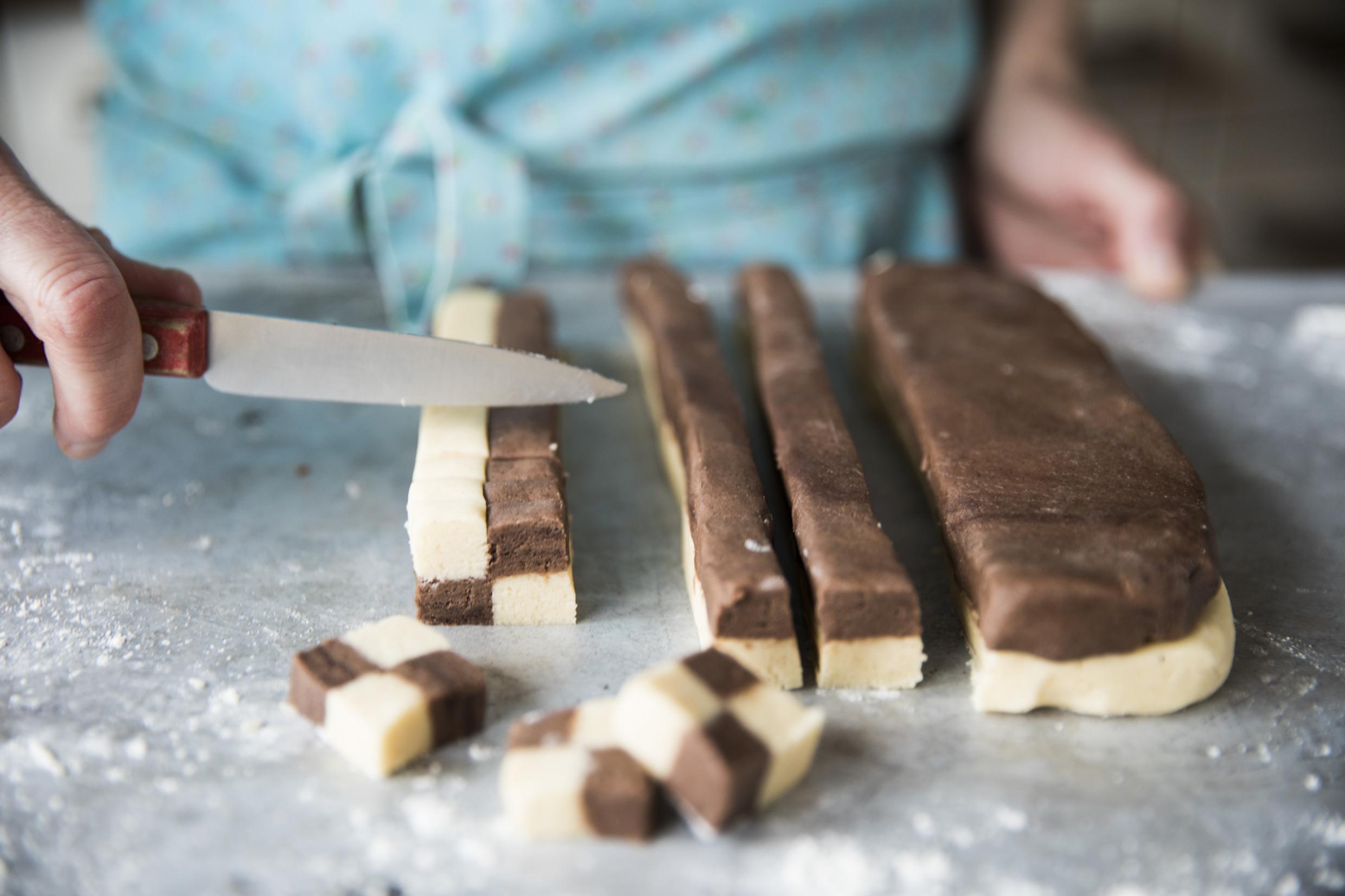 Une personne est en train de découper des biscuits pour en faire des Schackrutor.