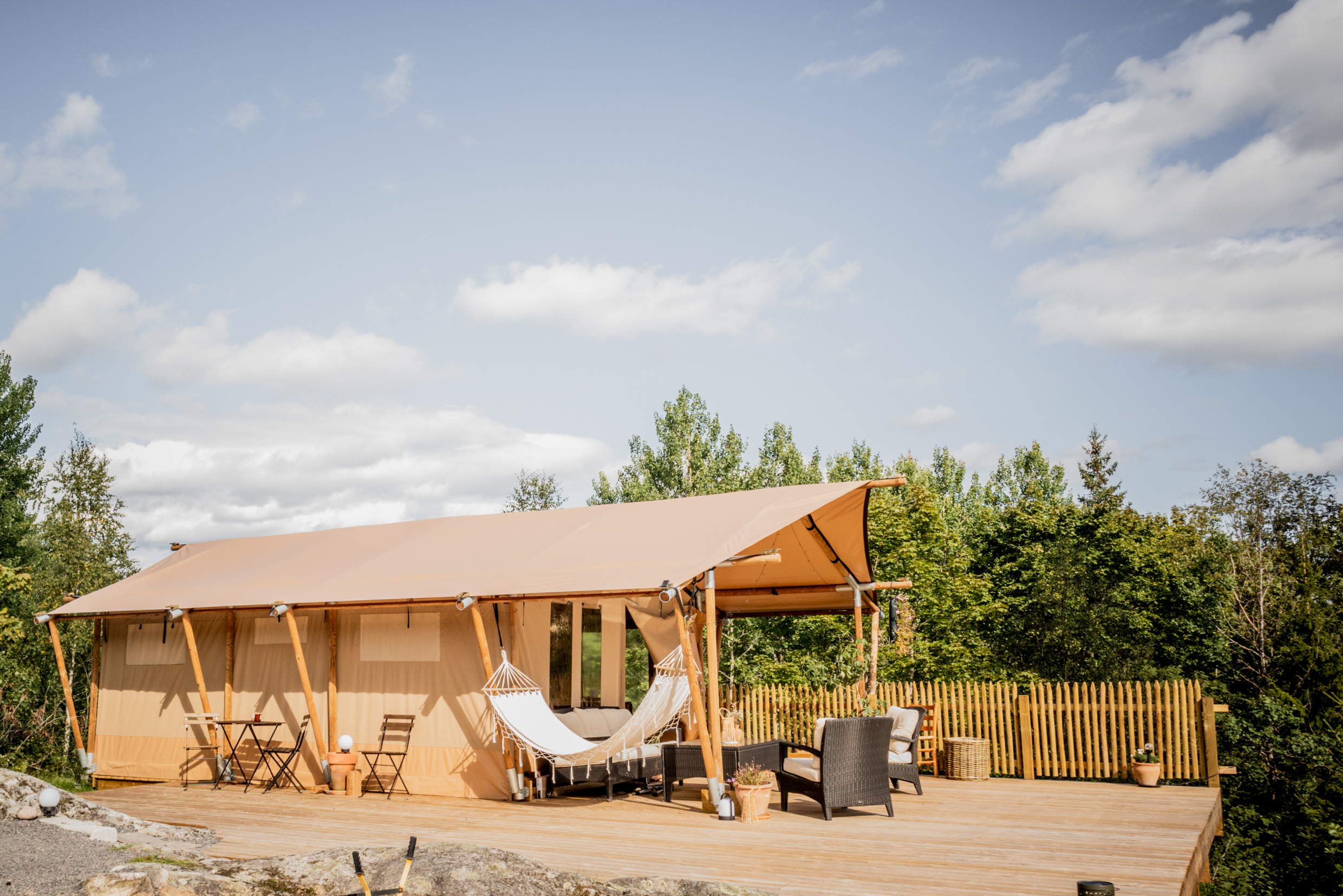 Een accommodatie met een patio. Buiten de accommodatie vind je een hangmat en stoelen.