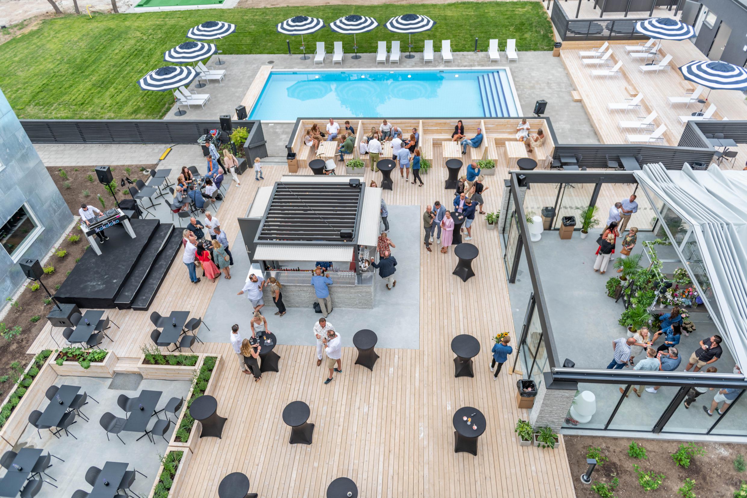 Een houten terras met een bar naast een zwembad in de zomer.
