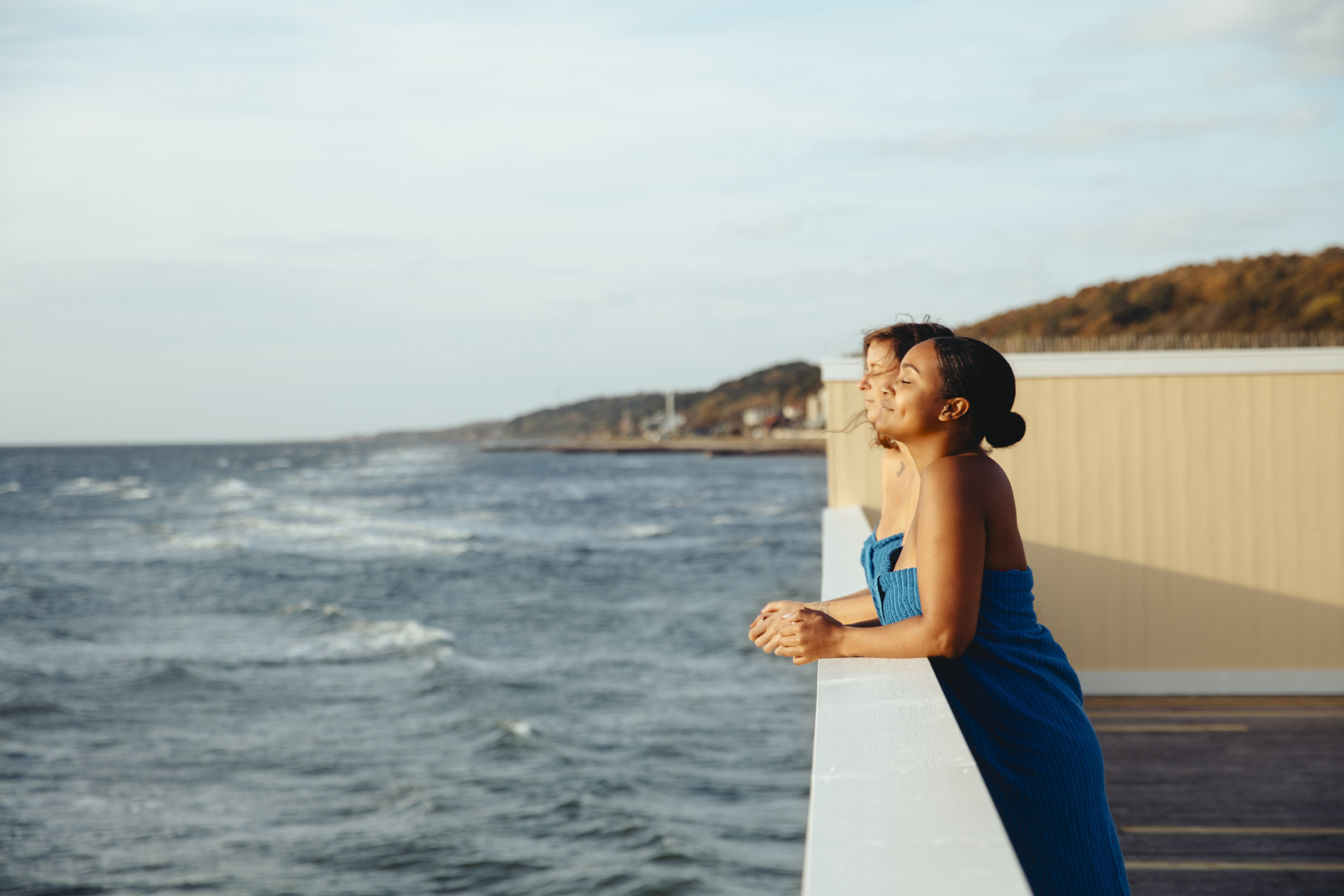 Zwei in Handtücher gehüllte Frauen genießen den Blick aufs Meer im Kaltbadehaus Pålsjöbaden in Helsingborg.