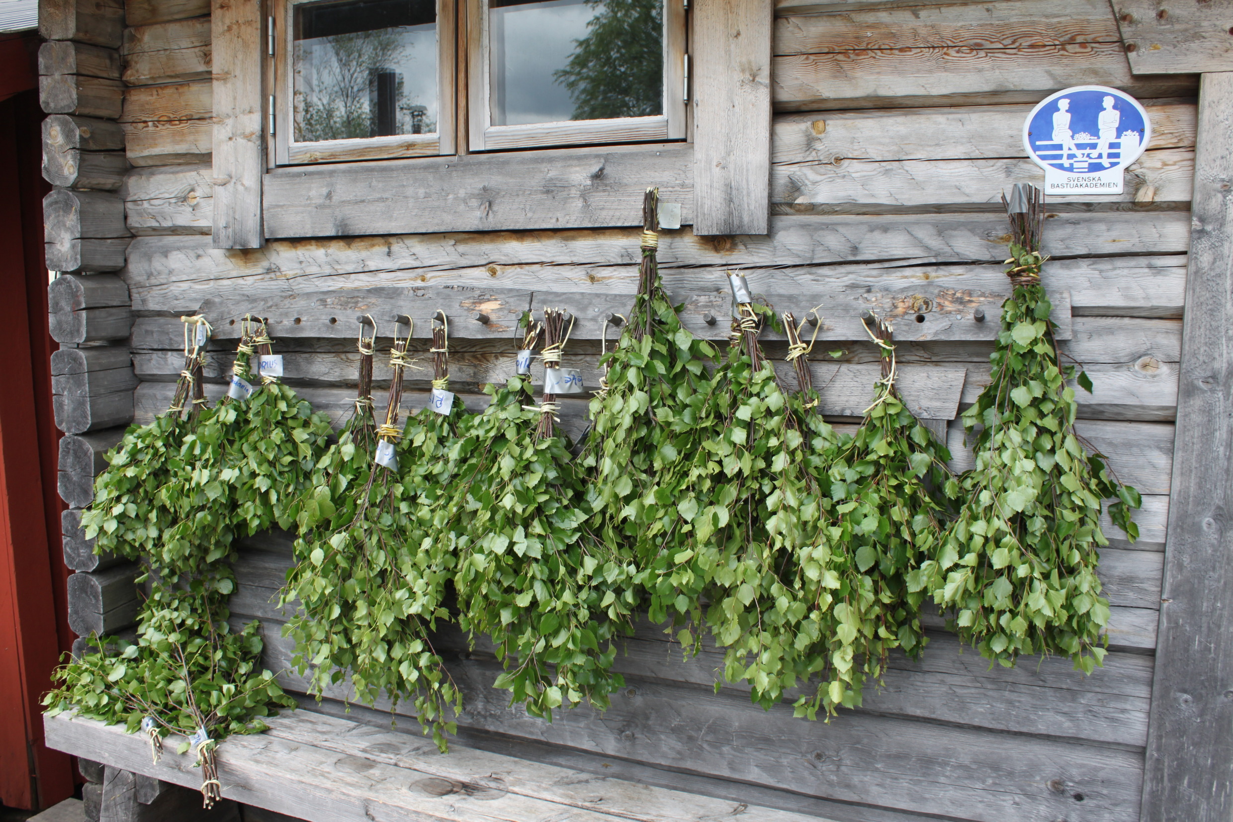 Boomtakken hangen aan de zijkant van een houten huis.