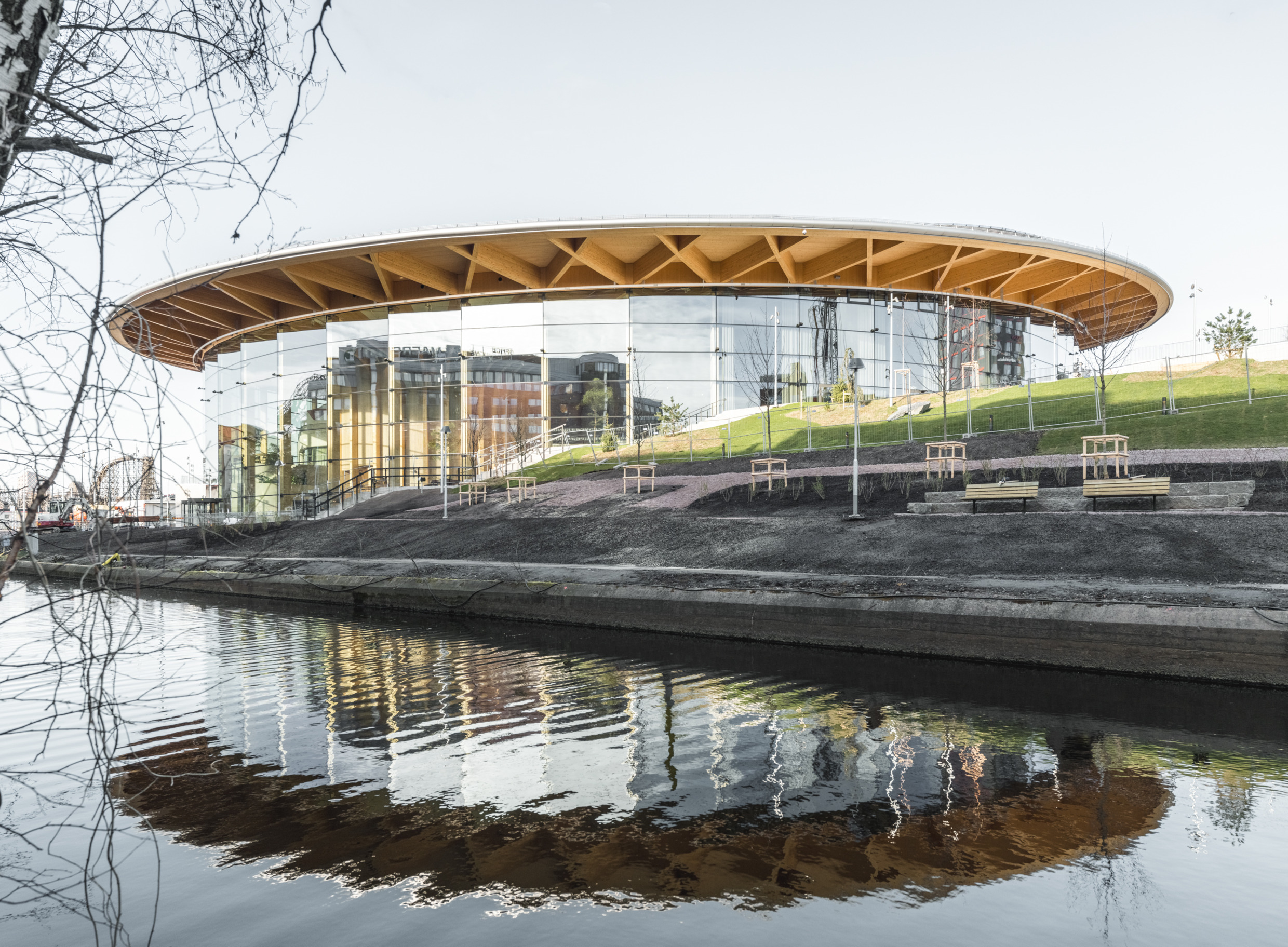 L'extérieur du bâtiment circulaire de cinq étages "World of Volvo" à côté d'une rivière.